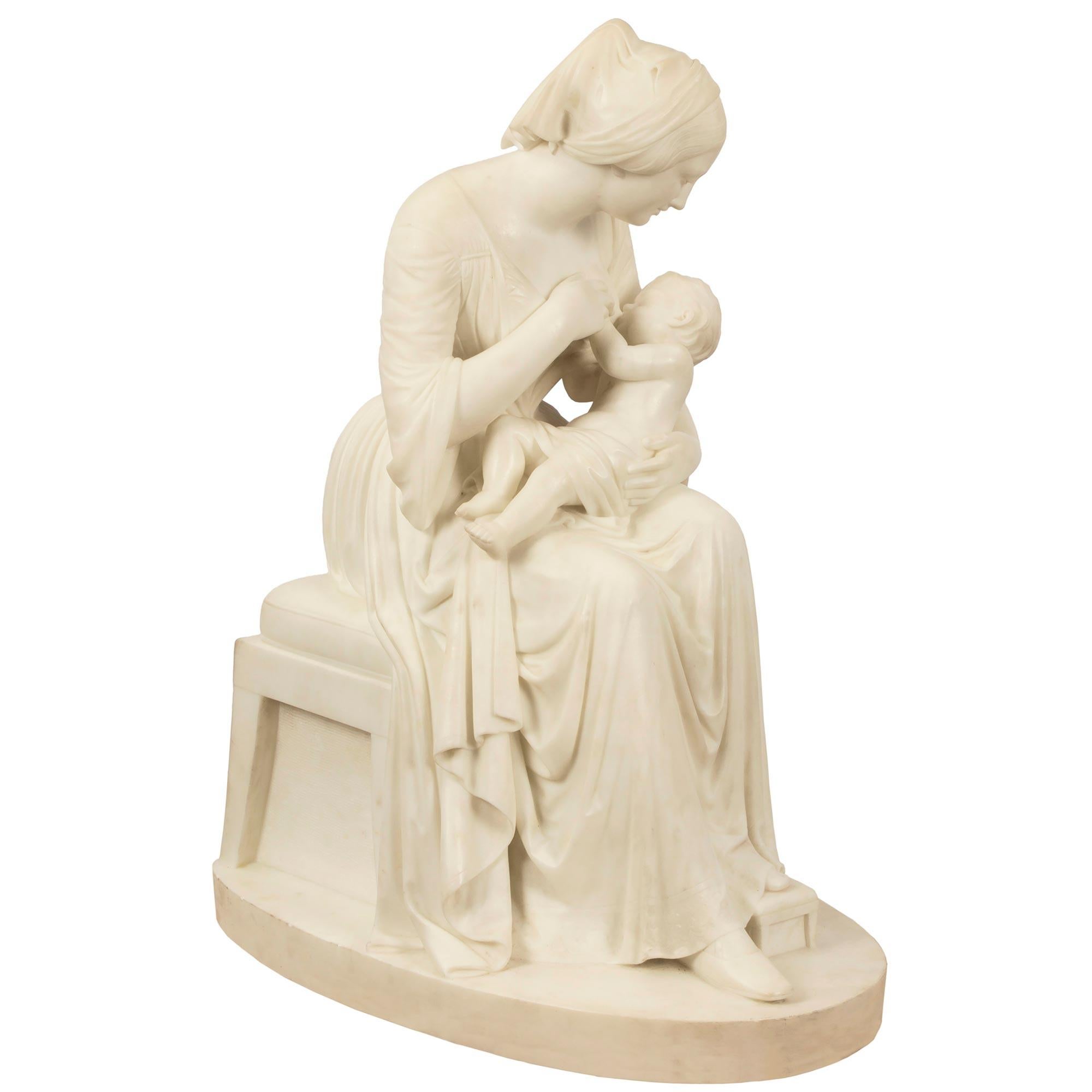 A charming and well executed Italian 19th century white Carrara marble statue of a mother breast feeding her child, signed P. Franchi, 1860. The statue is raised on an oval shaped base and is of a seated mother, in classical dress, with one leg