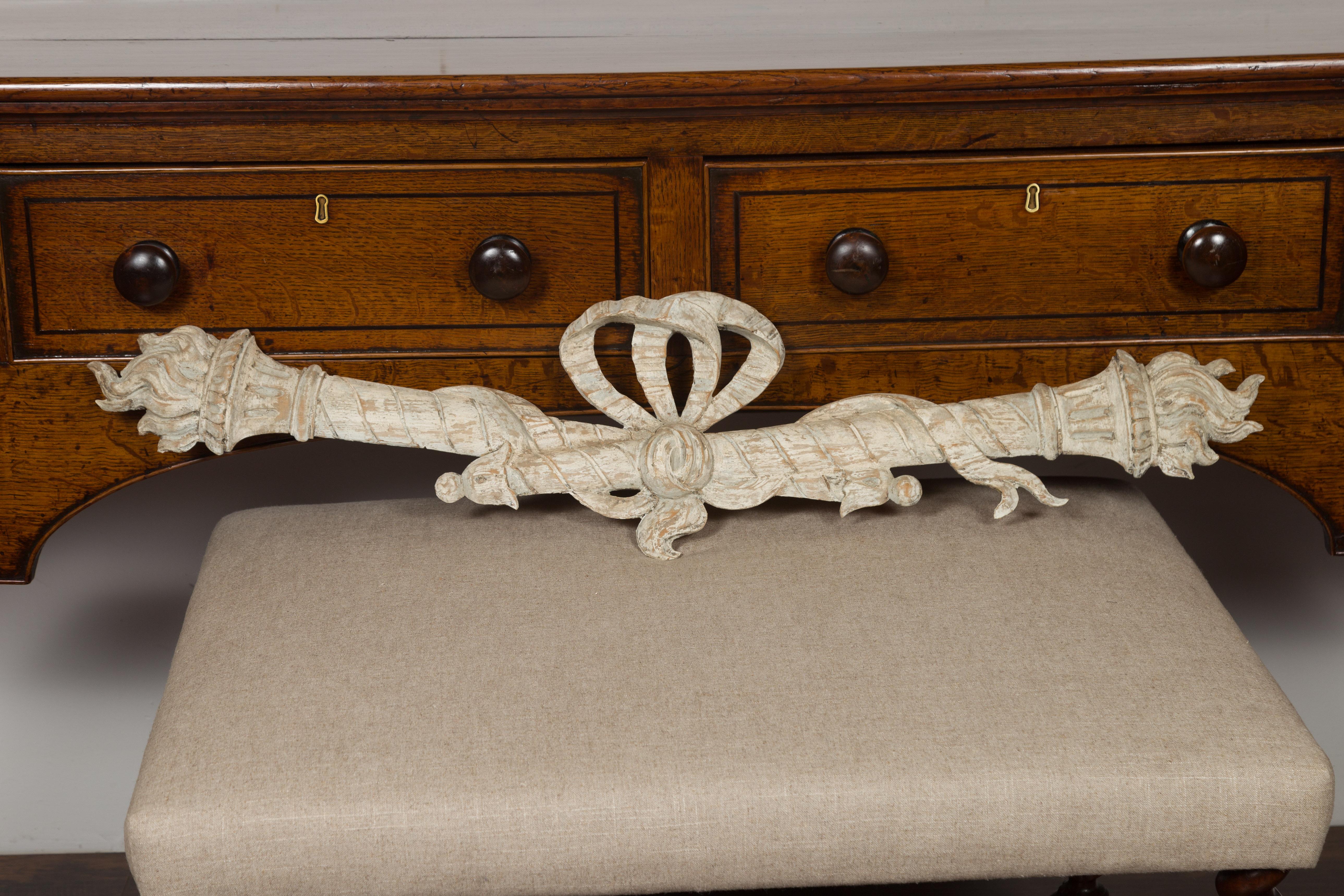 An Italian carved and painted architectural fragment from the 19th century, with ribbon-tied torches. Created in Italy during the 19th century, this horizontal carved fragment features a nicely distressed painted body with wood showing through,