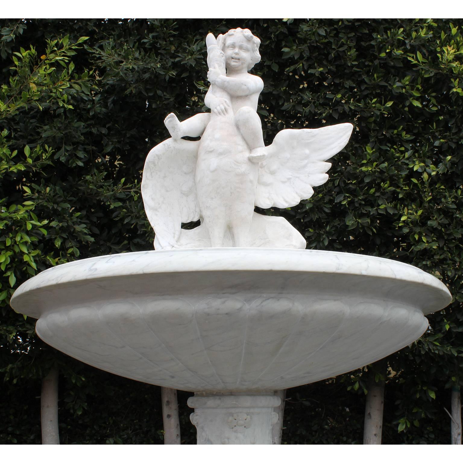 An Impressive Italian 19th century carved white marble figural fountain. The circular carved marble basin surmounted with a carved marble figure of a Putto raiding on a goose, all raised on an ornately carved pedestal stand on a square marble