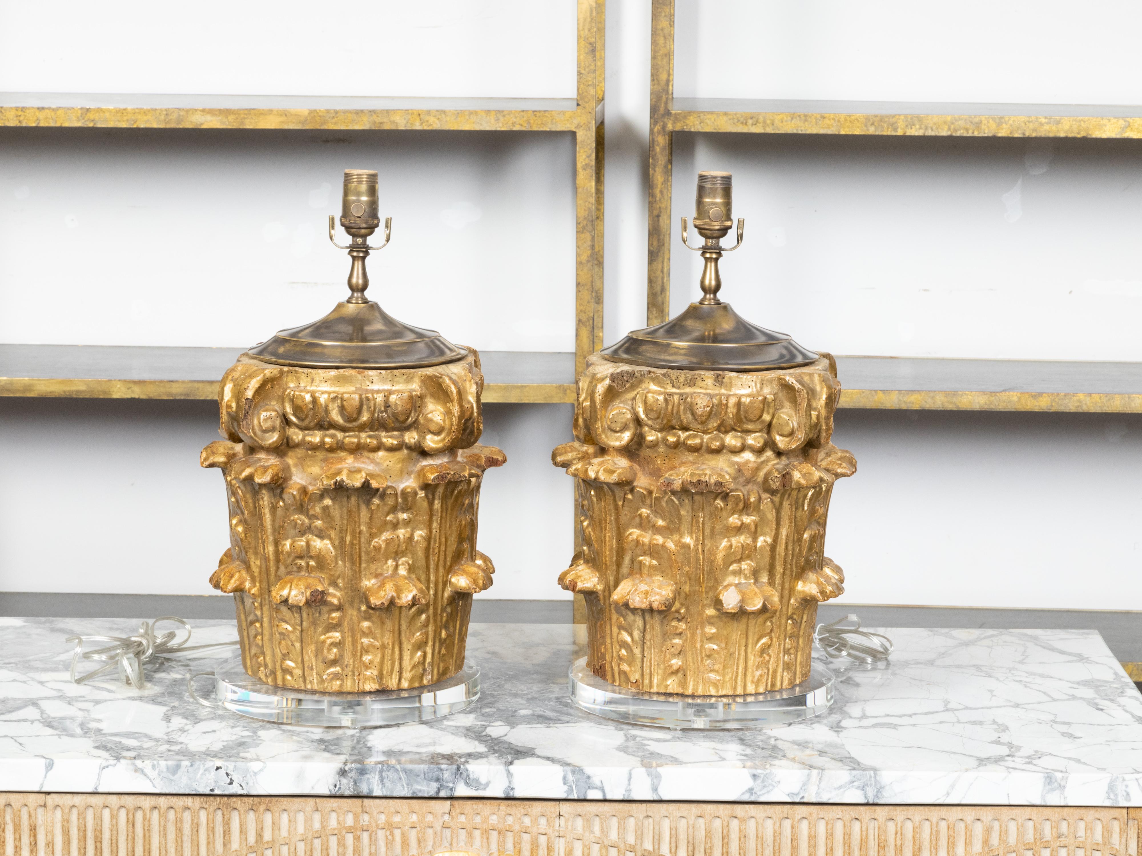 A pair of Italian giltwood Composite capitals from the 19th century, mounted recently on round lucite bases and made into table lamps wired for the US. Created in Italy during the 19th century, each piece features a giltwood Composite capital,