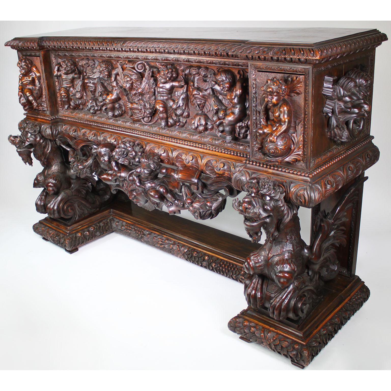 A Fine and Large Italian Florentine 19th Century Baroque Revival Style Carved Walnut Figural Cassone Chest on Stand. The ornately carved drop-front cassone with an allegorical in-relief carvings depicting playful Putti among satyrs, fruits and