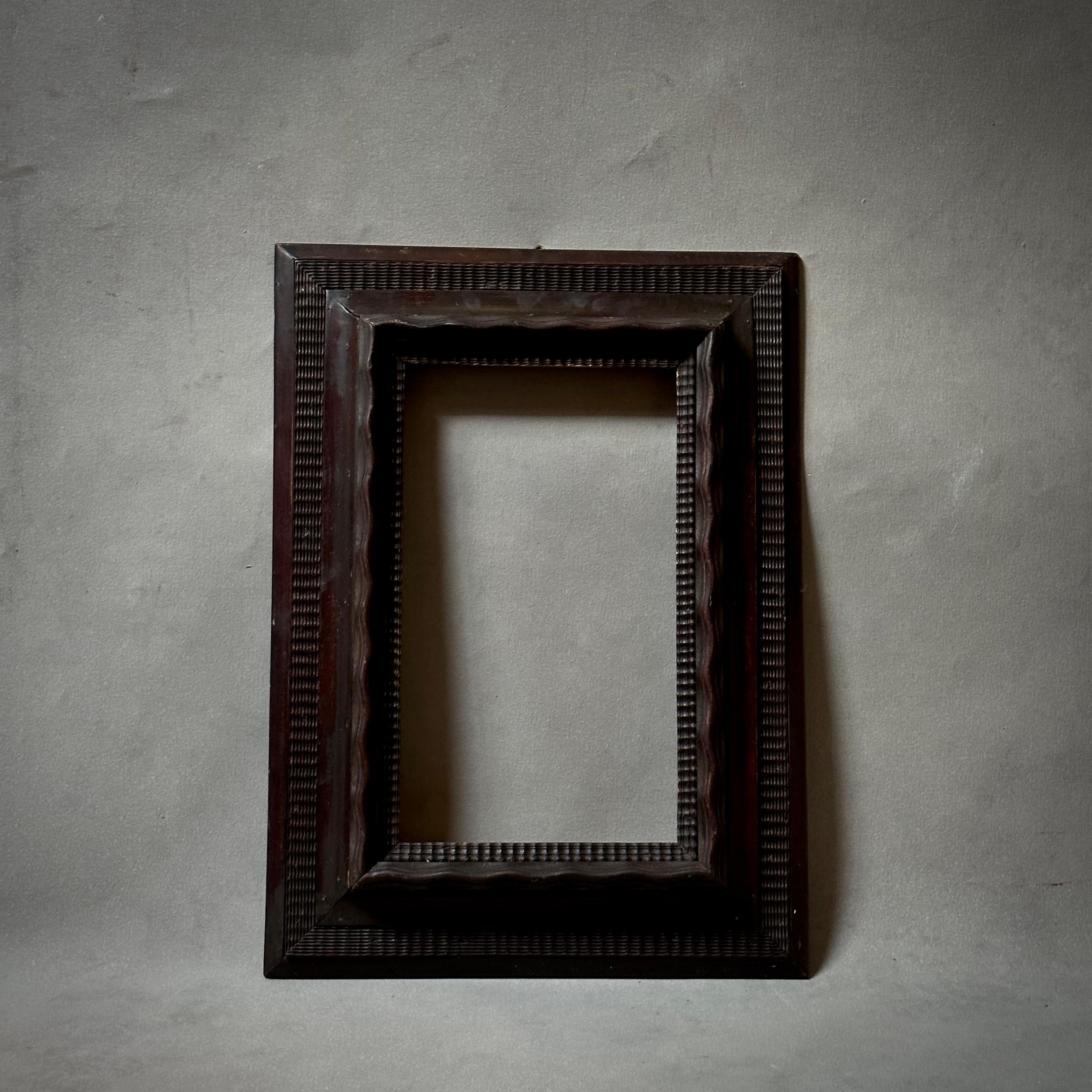 Deeply stained rectangular carved wood frame with graphic carved detailing from late nineteenth century Italy. Substantial yet understated with unique detailing.

Italy, circa 1880

Dimensions: 15.5W x 3D x 22H (8.75 x 14.5 inside).