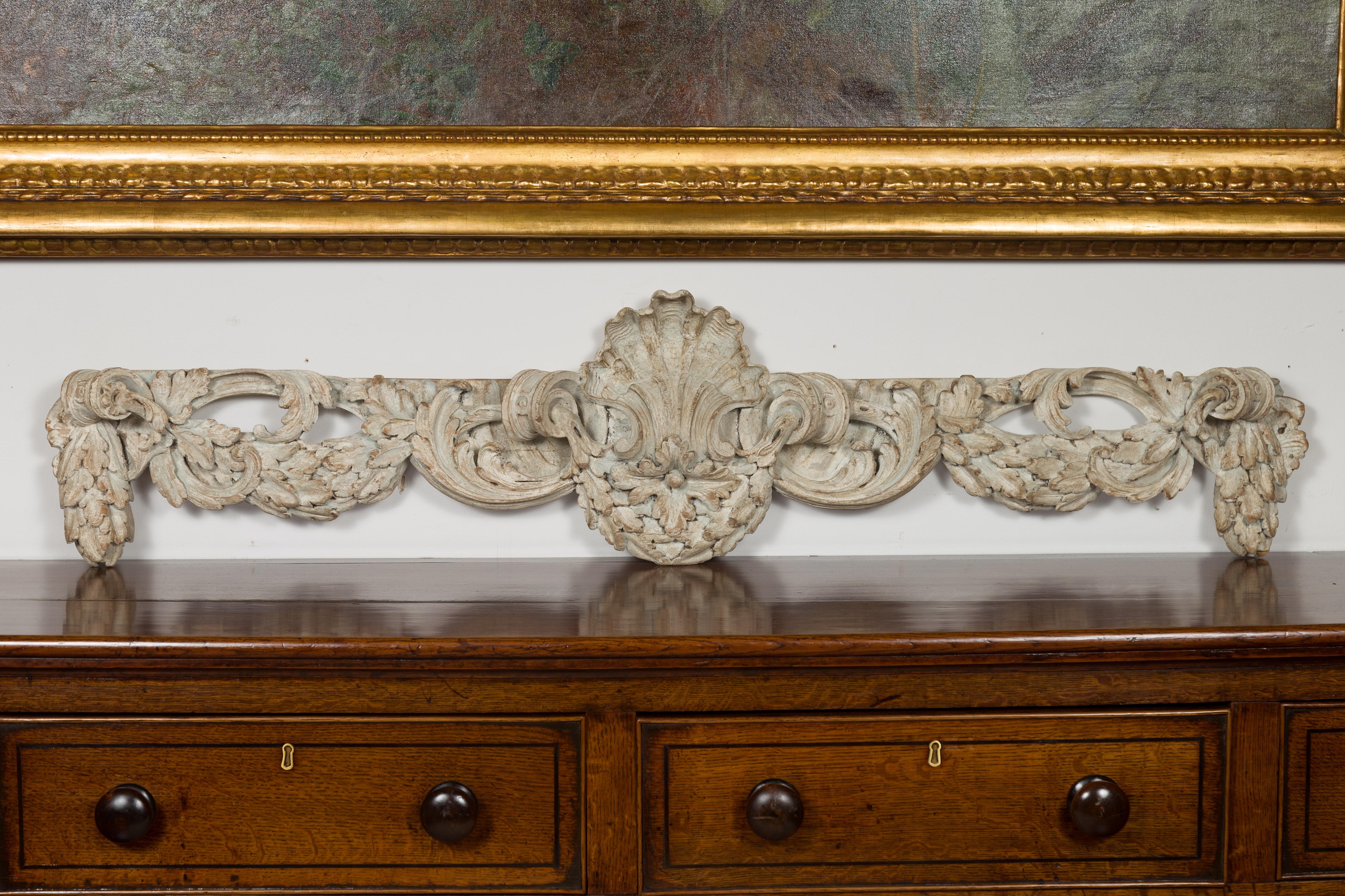 An Italian carved wooden architectural swag fragment from the 19th century, with shell and foliage motifs. Created in Italy during the 19th century, this carved and painted fragment will look wonderful hung on a wall. Featuring a swag accented with