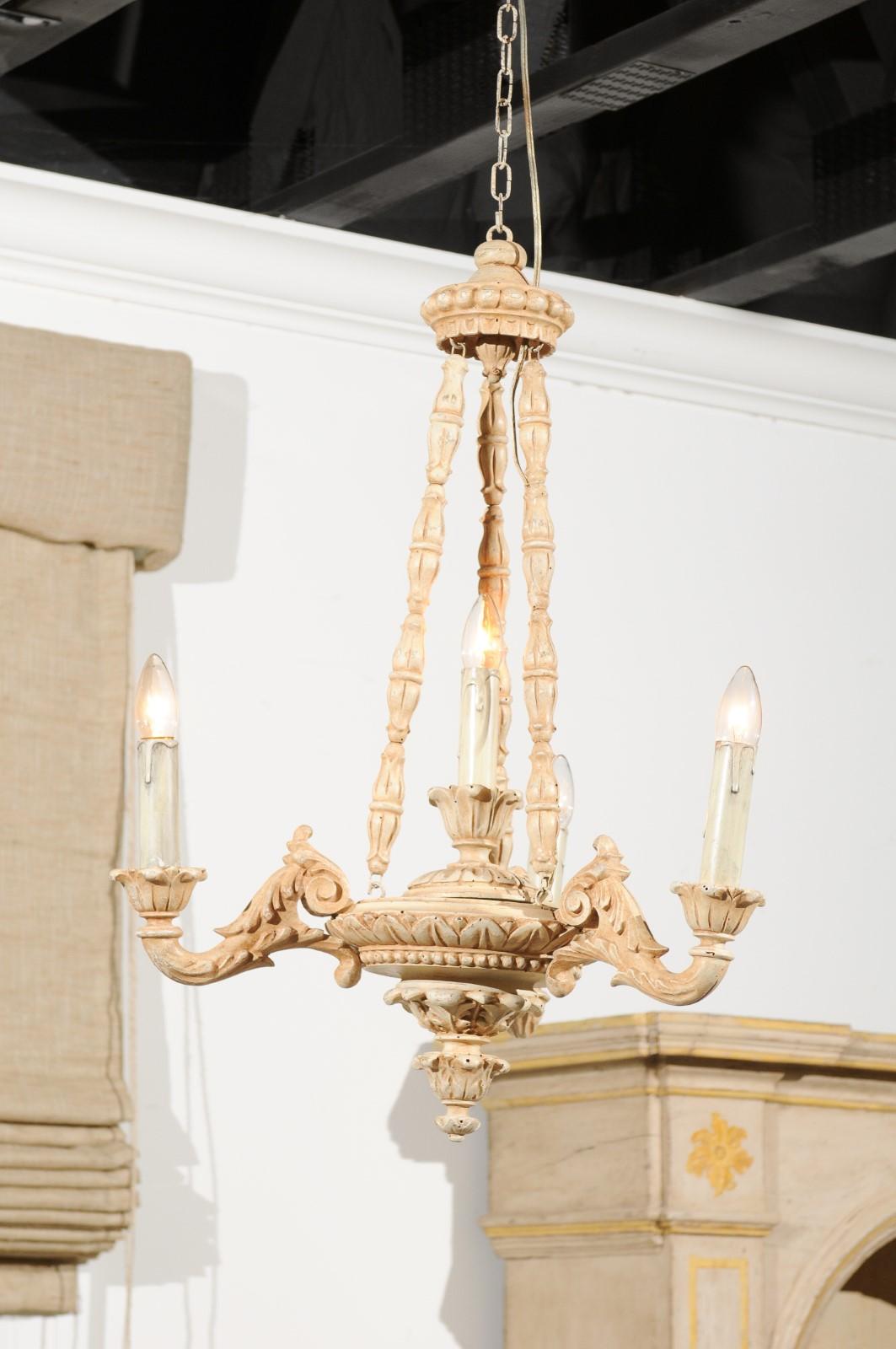 An Italian painted and carved wooden three-light chandelier from the 19th century, with scrolling arms and rais-de-cœur motifs. Born in Italy during the 19th century, this chandelier features a crown-shaped canopy connected to three carved wooden