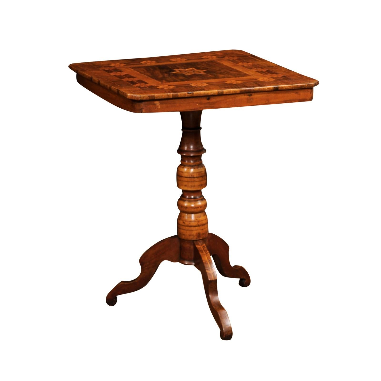 An Italian walnut, mahogany and European birch center table from the 19th century, with geometric and star shaped marquetry decor and turned pedestal. Created in Italy during the 19th century, this inlaid center pedestal table features a nearly