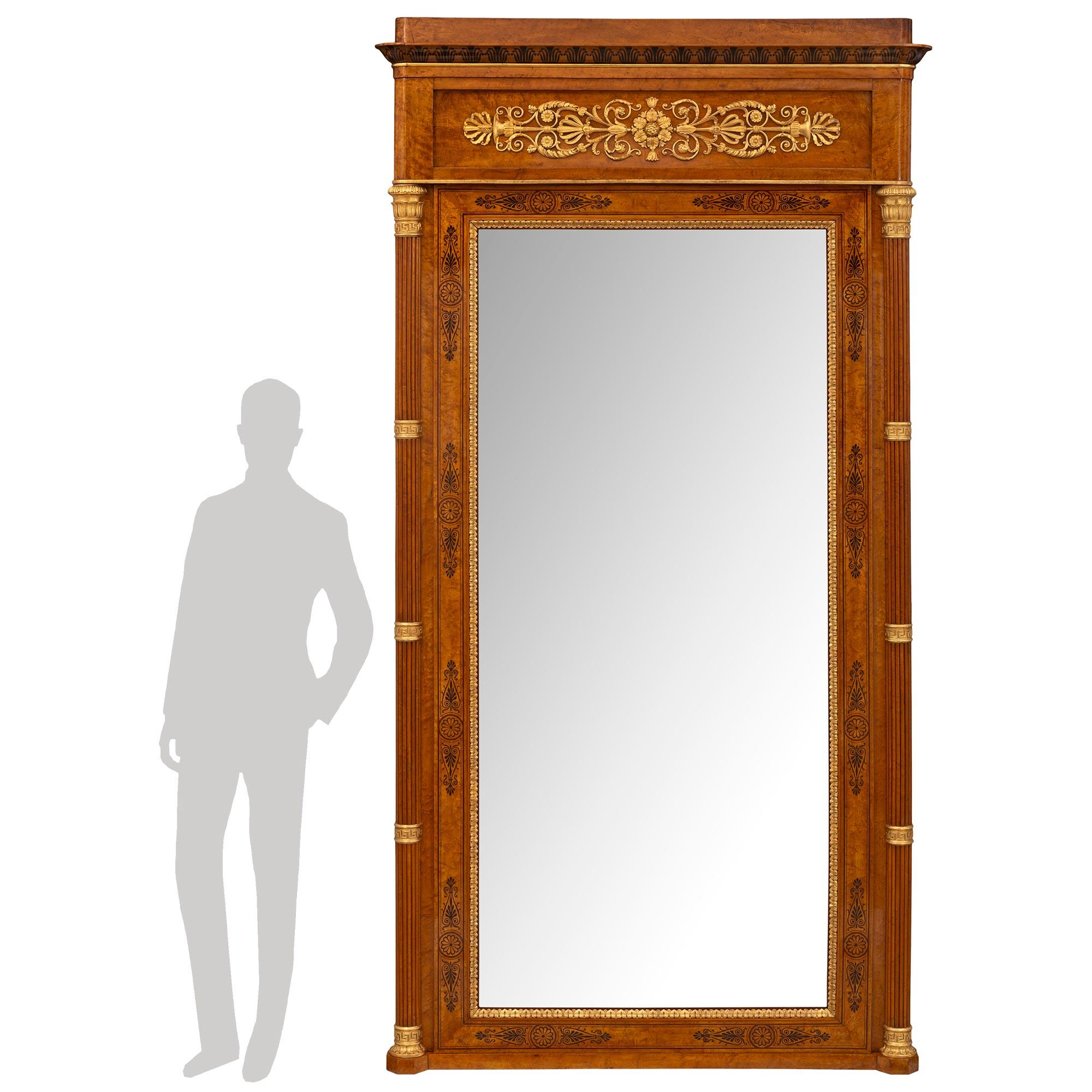 An impressive and most unique Italian 19th century Charles X period walnut, burl walnut and giltwood mirror. The large scale mirror retains it's original mirror plate framed in a charming and finely detailed giltwood foliate wrap around band with