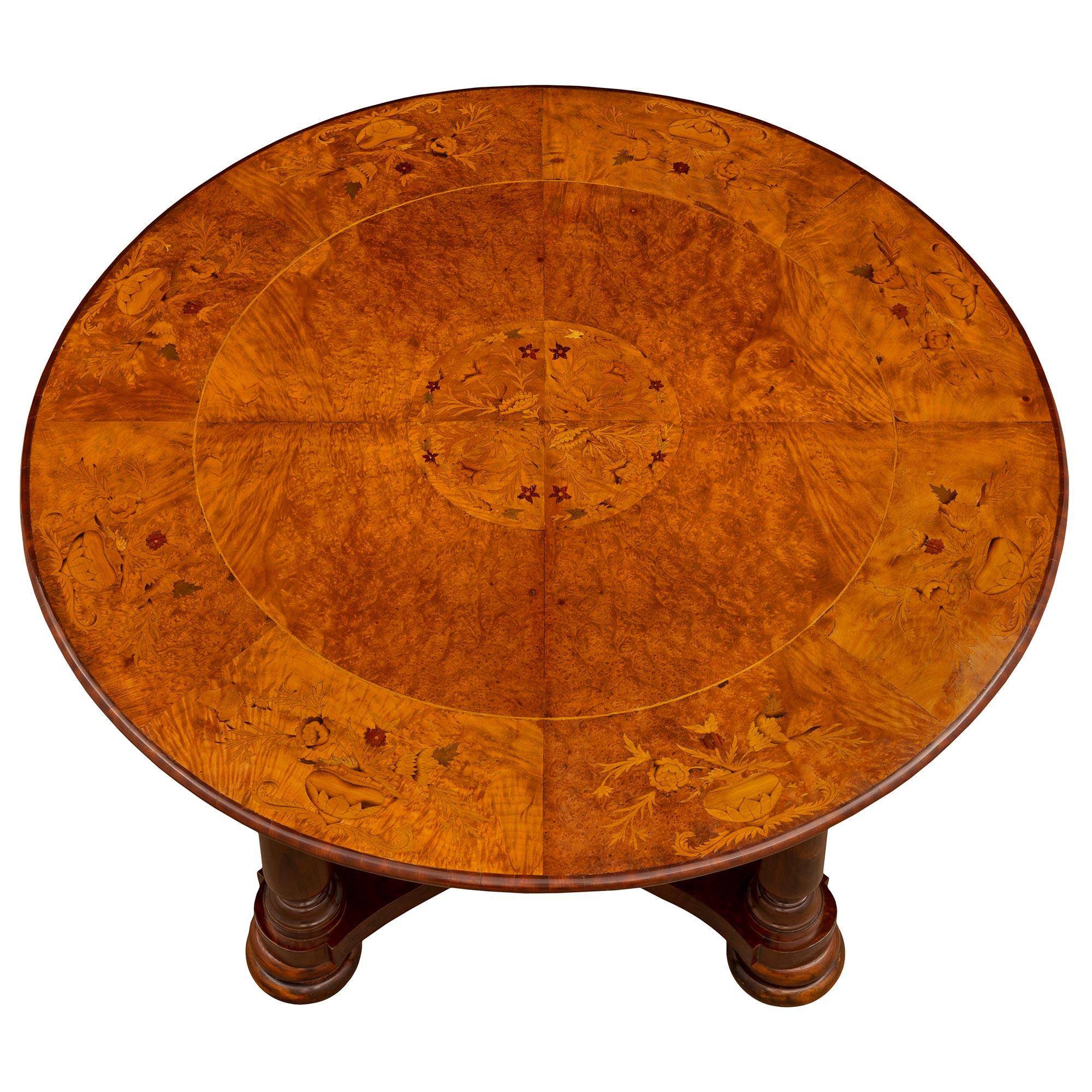 Une belle table de centre italienne du 19ème siècle en noyer, noyer ronce, orme ronce et bois exotique. La table circulaire est surélevée par des pieds en forme de chignon doublement tachetés très décoratifs, sous des pieds circulaires tournés et