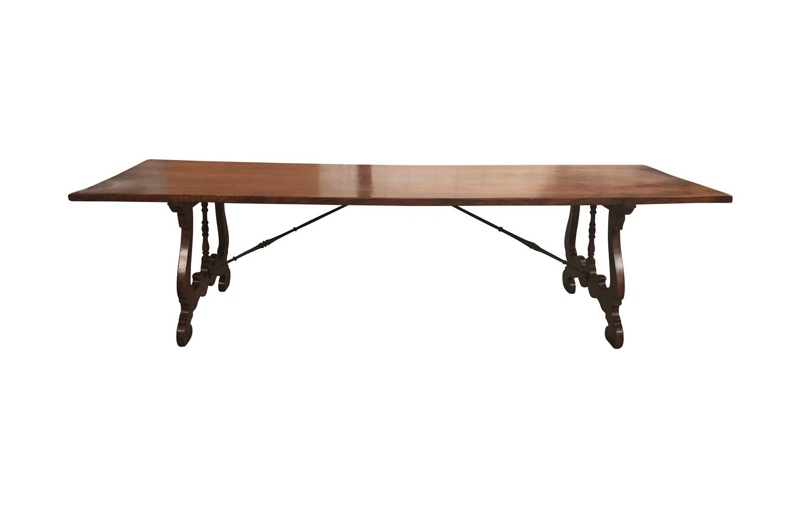 A stunning later 19th century dining table from northern Italy. Beautifully constructed from chestnut and hand forged iron stretchers with a nice thick top and classical lyre shaped legs. Wonderful patina and graining - rich and luminous.