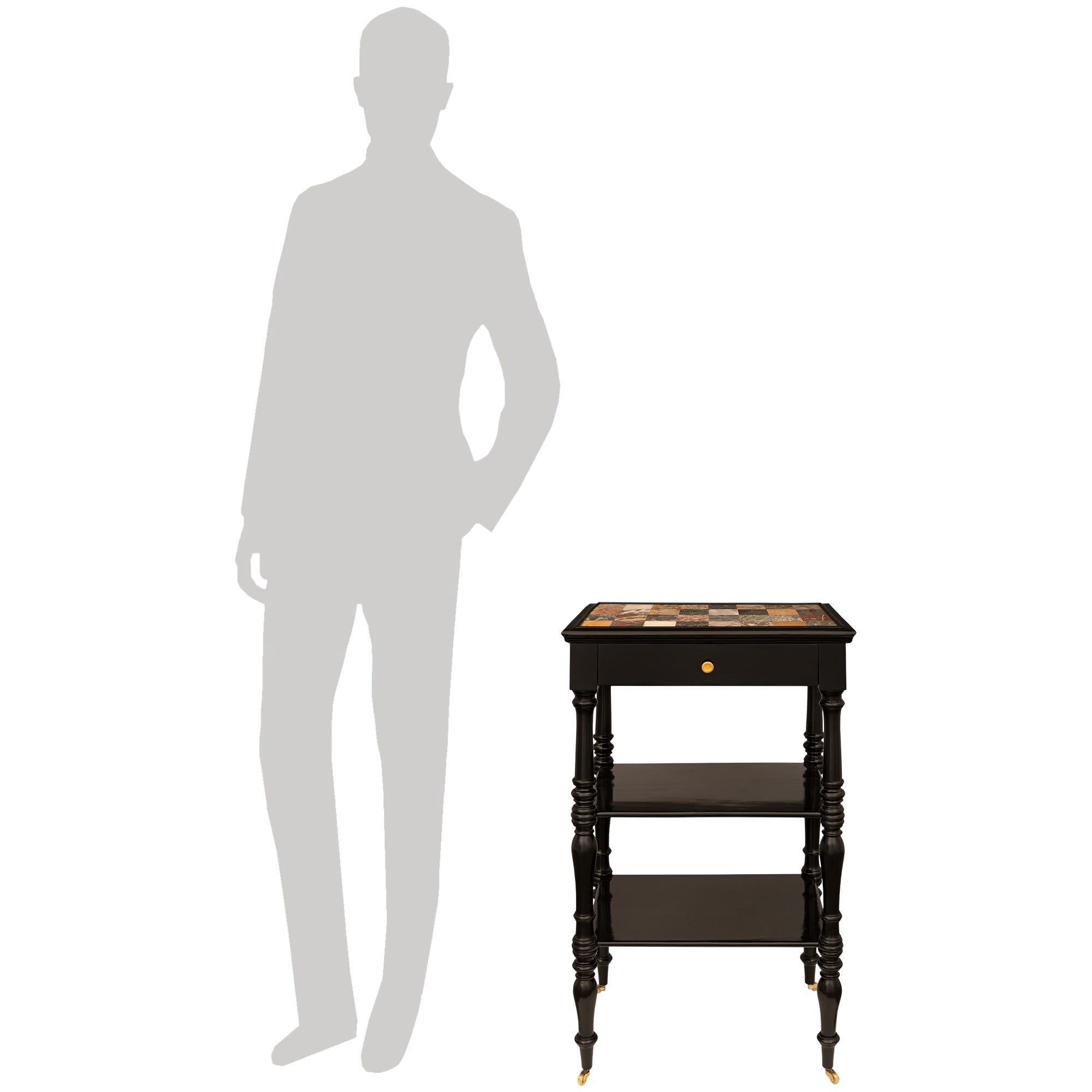 A handsome and most decorative Italian 19th century ebonized Fruitwood, Ormolu and Specimen Marble side table. This charming three tiered table is raised on Ormolu casters below the baluster shaped legs with mottled bands throughout. The four legs