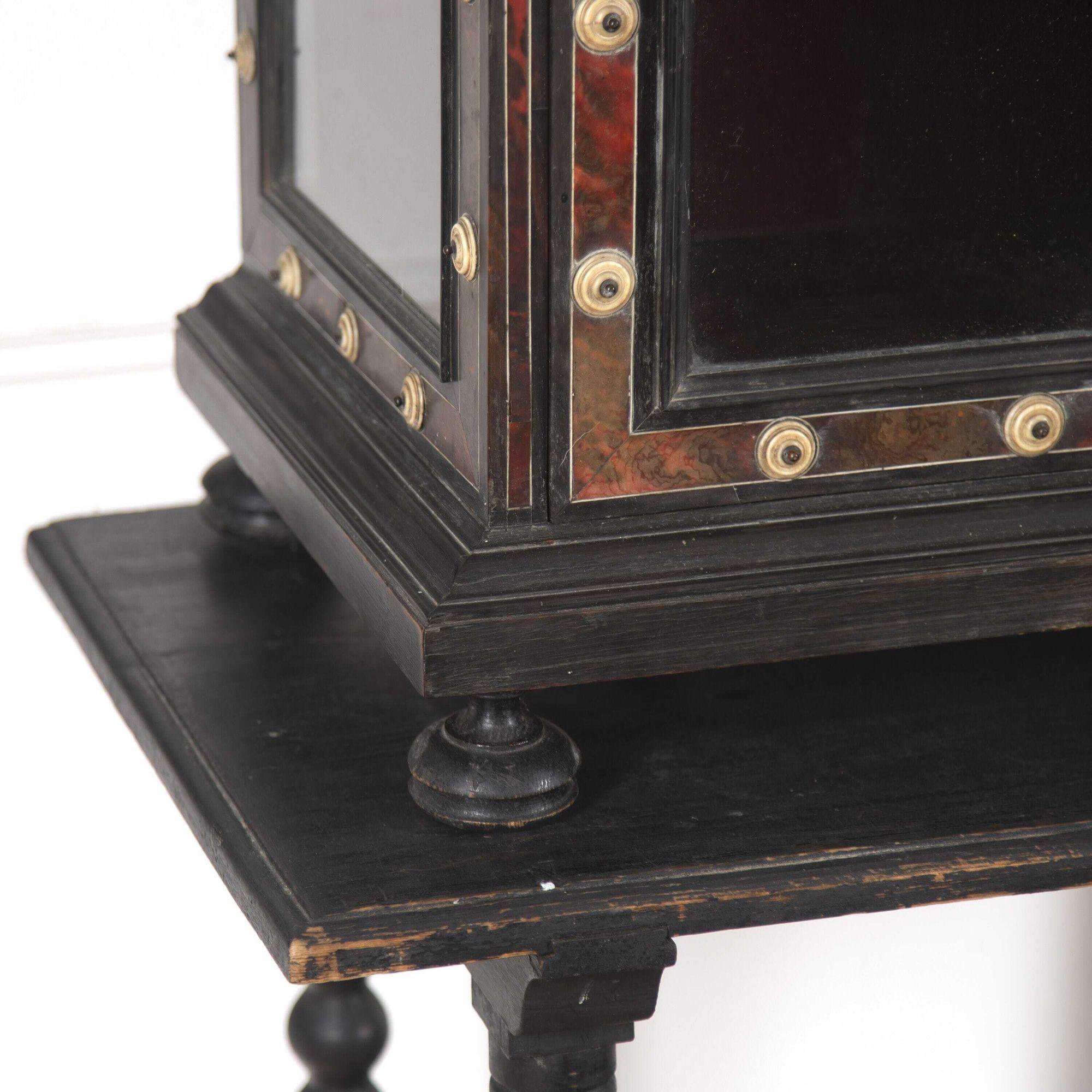 Highly decorative Italian 19th century ebony and tortoiseshell cabinet on stand.
This striking cabinet features an ebony framework with a gallery of turned balustrades, bone roundels and decorative finials to the top, which can simply lift off for