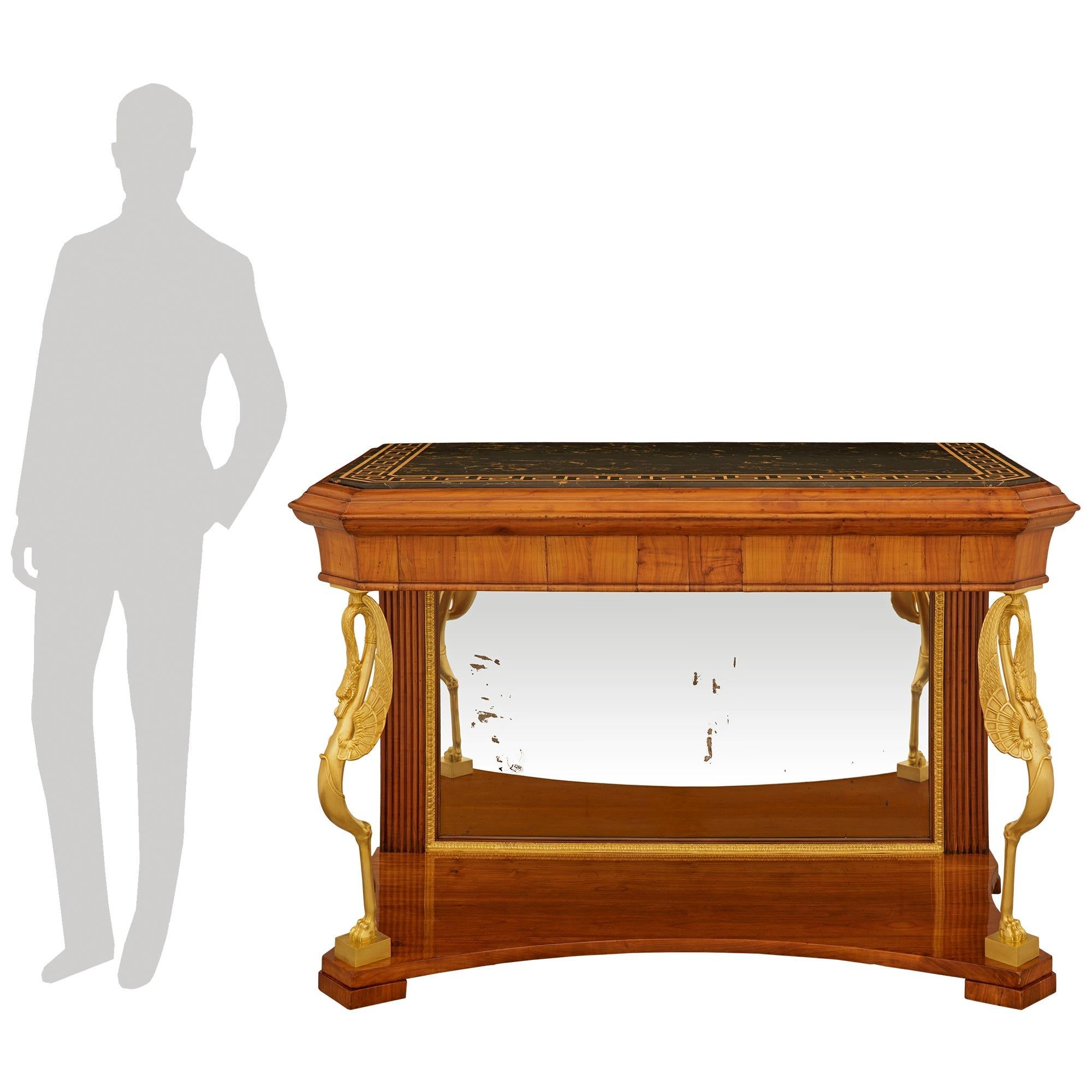 An impressive and most decorative Italian 19th century Empire st. Cherrywood, Ormolu, Mirror and marble console. This stunning freestanding console is raised on four block feet supporting a Cherrywood lower display tier with inward curved edges, and