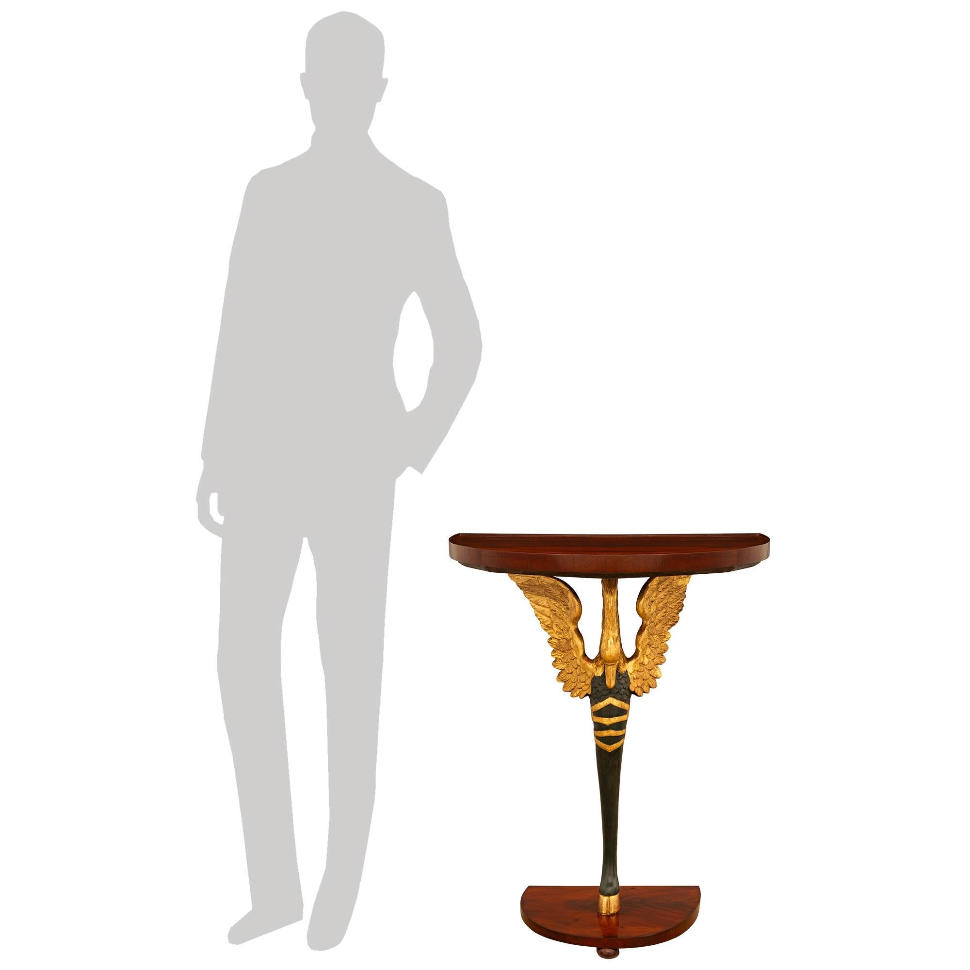 A stunning and most decorative pair of Italian 19th century Empire st. Mahogany, Giltwood, and patinated Wood console tables. Each unique freestanding demi lune console is raised by an 'S' scrolled patinated wood tapered cabriole leg on a Giltwood