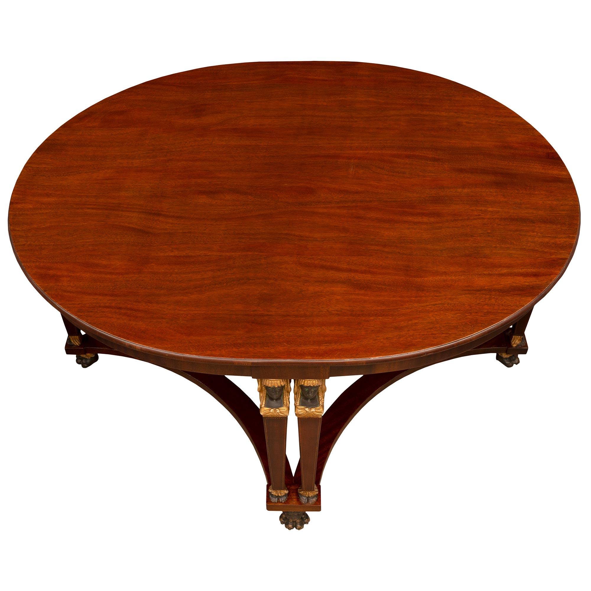 An impressive and most handsome Italian 19th century Neo-Classical st. Mahogany, polychrome, and giltwood center table. The oval table is raised by striking and most unique lion head and paw feet below four pairs of rare beautiful double leg