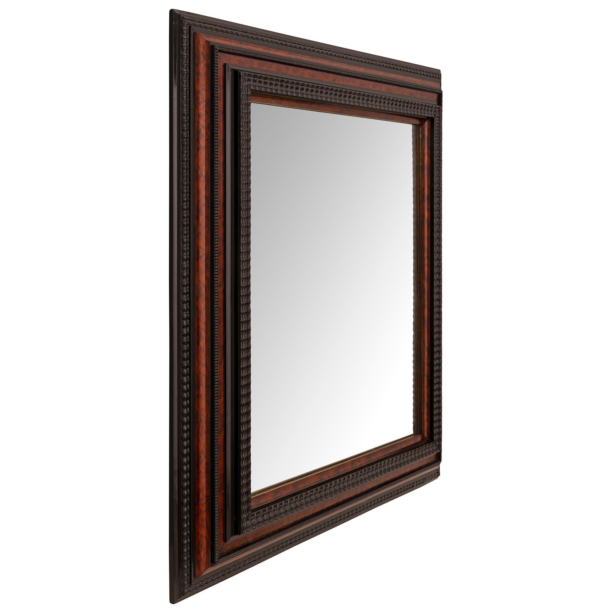 An impressive and extremely decorative Italian 19th century Florentine st. ebonized fruitwood and exotic wood mirror. The original mirror plate is framed within a wonderfully executed mottled stepped frame with wonderful wavy and beaded designs