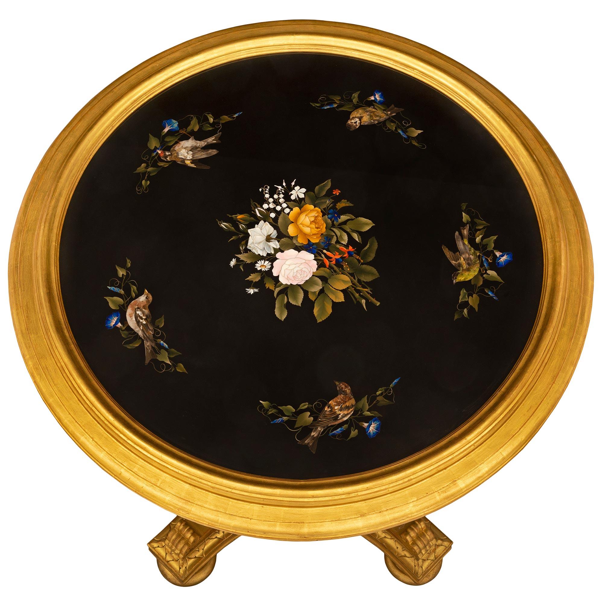 Superbe table d'appoint en bois doré et en pietra dura de très grande qualité, datant du 19e siècle, en provenance de Florentine. La table circulaire est surélevée par une belle base carrée aux côtés concaves et aux angles coupés, avec des pieds