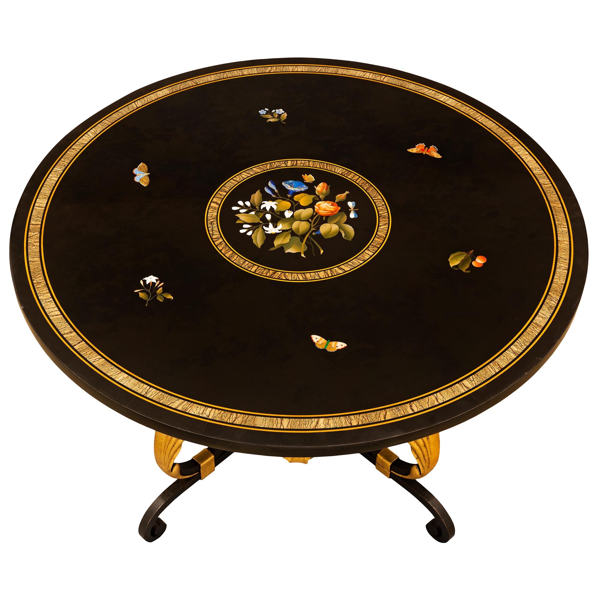 Superbe table de cocktail extrêmement décorative en fer forgé, métal doré et marbre Pietra Dura, datant du XIXe siècle. La table circulaire est surélevée par une saisissante base en fer forgé avec de magnifiques motifs à volutes et d'exceptionnels