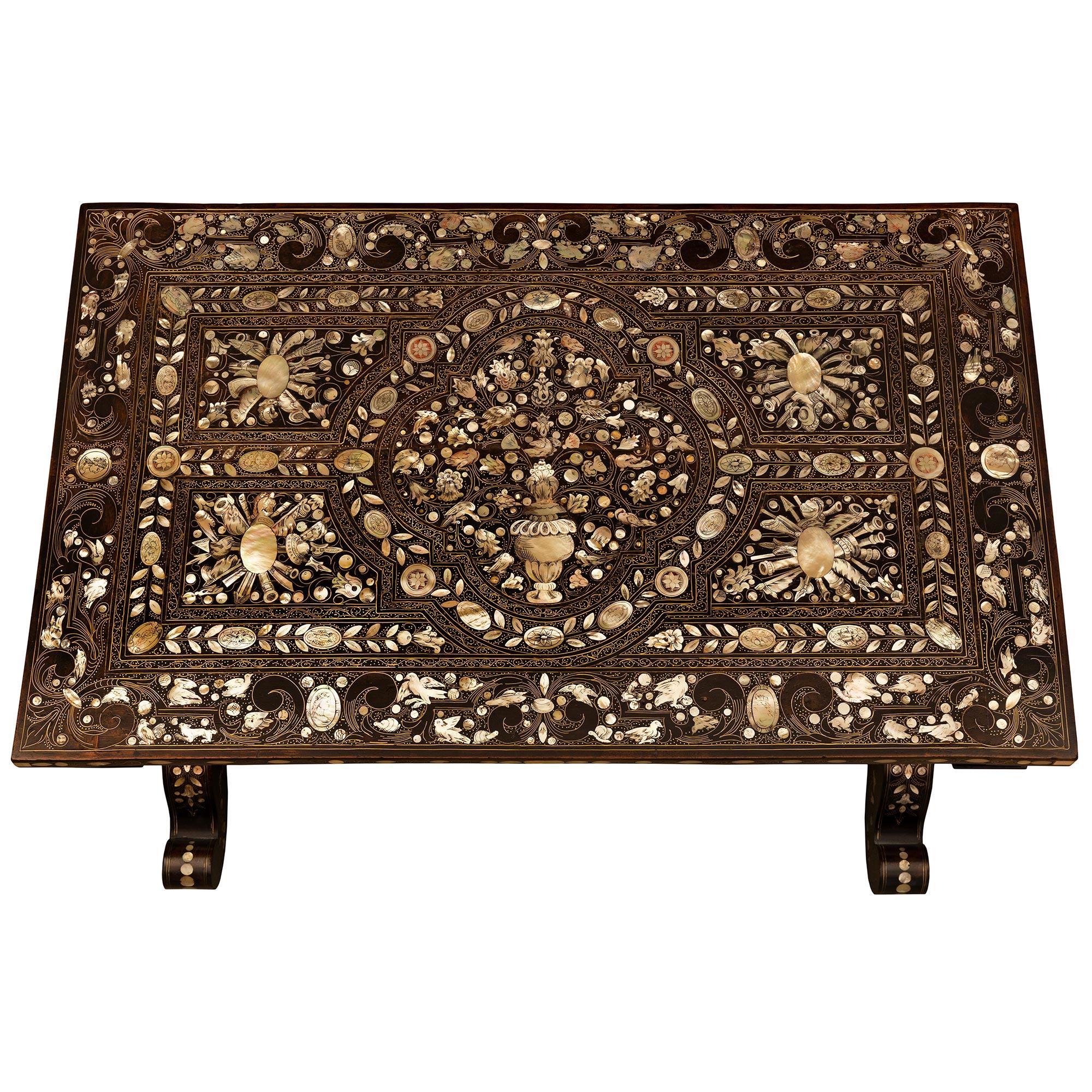 A stunning and extremely decorative Italian 19th century ebonized Fruitwood, brass, bone, and mother of pearl side table. The table is raised by fine casters below the beautifully scrolled legs with an exceptional array of inlaid mother of pearl and