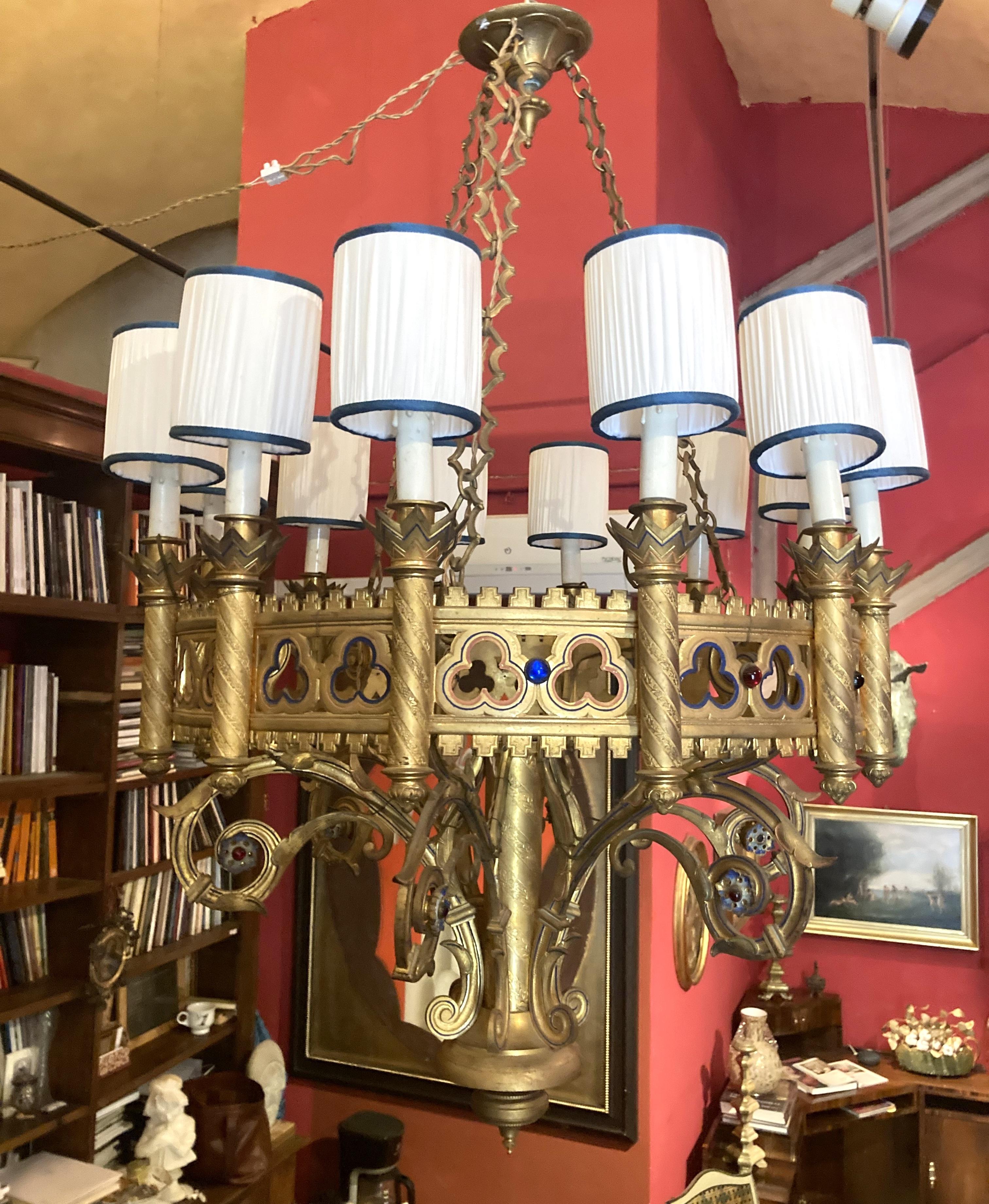 Questo antico lampadario a sospensione neogotico in bronzo dorato e smalto del XIX secolo, risalente al 1850 circa, è uno splendido lampadario artigianale disegnato a forma di corona d'avvento con cerchi smerlati e traforati a forma di quatrefoil,