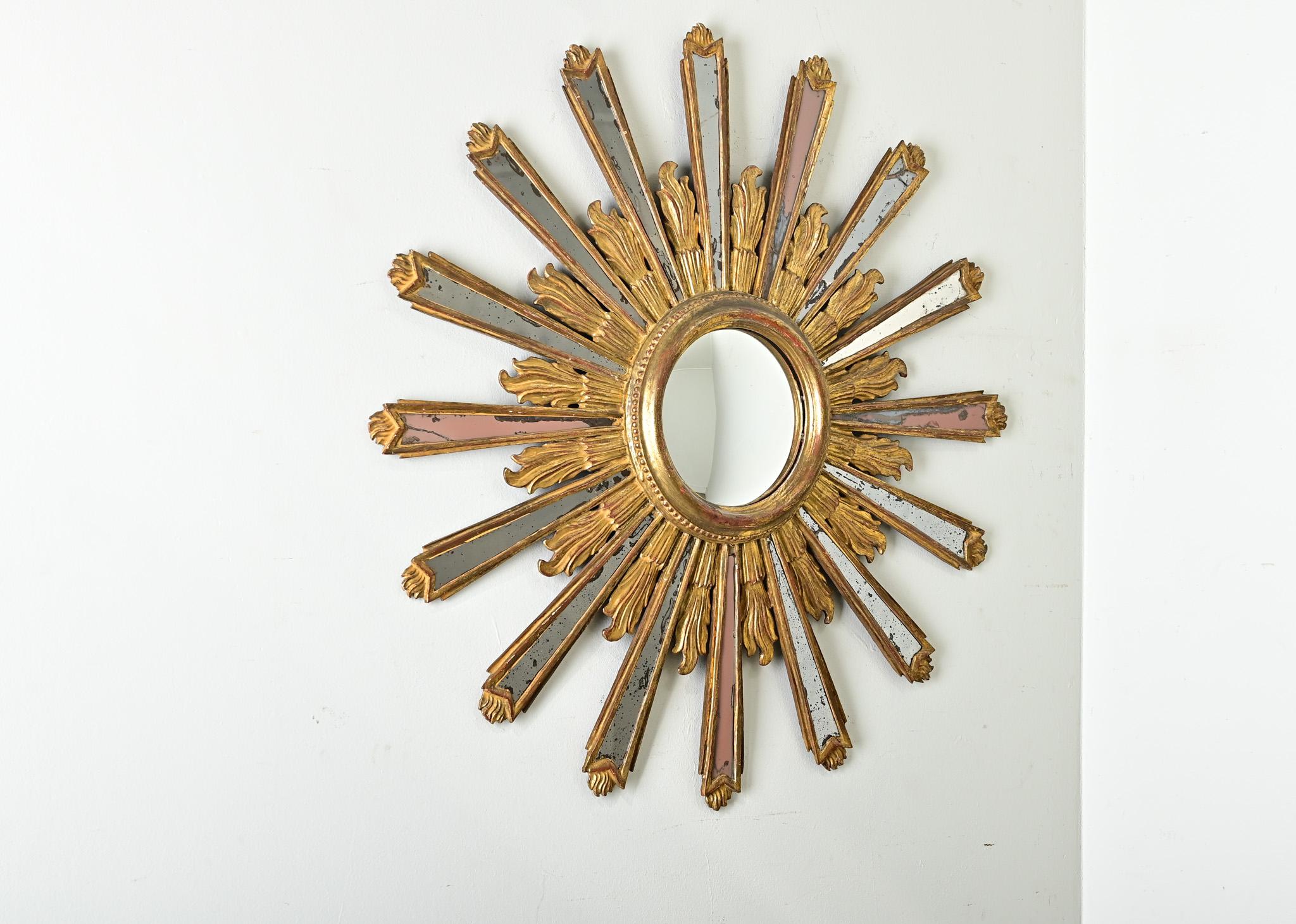 Miroir italien du XIXe siècle à effet d'étoile, avec alternance de rayons solaires en verre miroir et de flammes en bois sculpté et doré, qui rayonne d'énergie tout en attirant l'observateur pour un regard plus attentif. Chaque petit morceau de