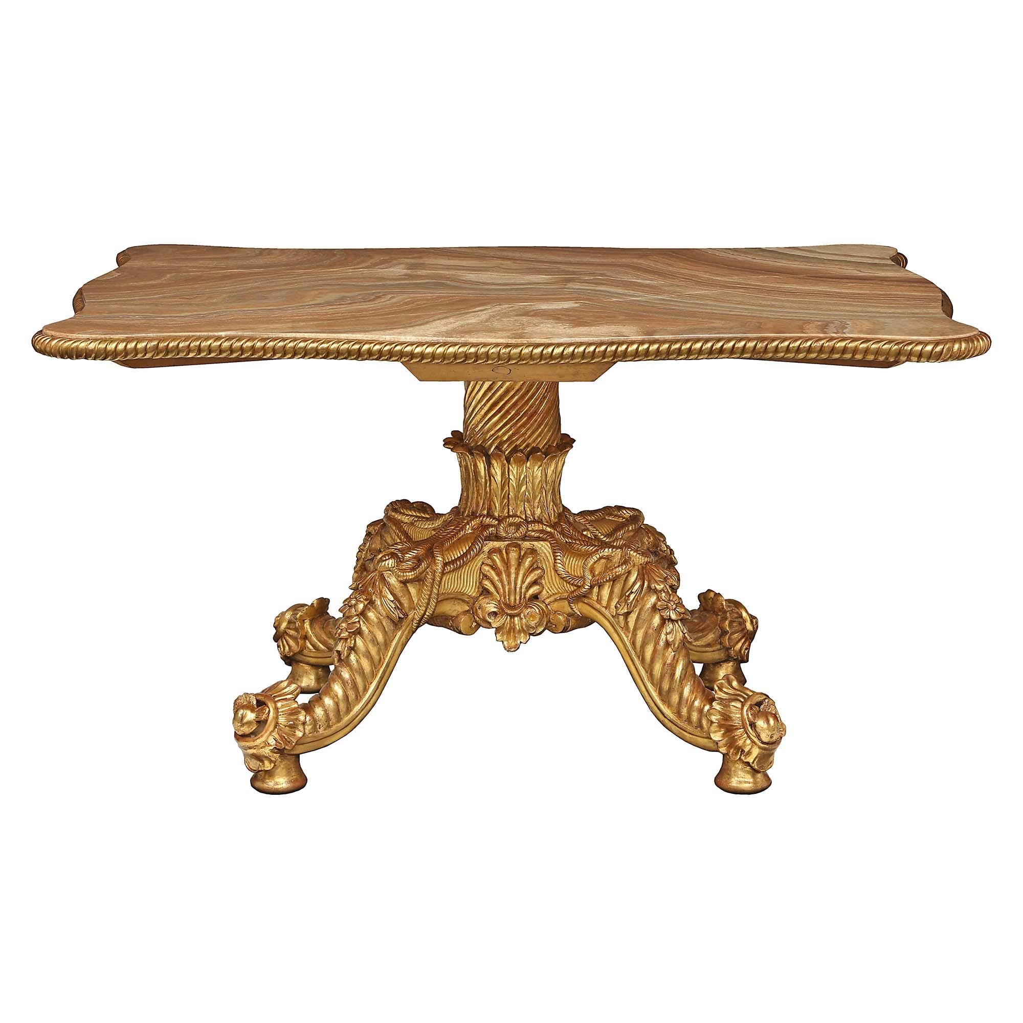 A spectacular Italian 19th-century giltwood and onyx center table. The table is raised by an intricate and richly carved base with four handsomely poised legs. Each leg is elegantly decorated with a twisted rope design and adorned with fine floral
