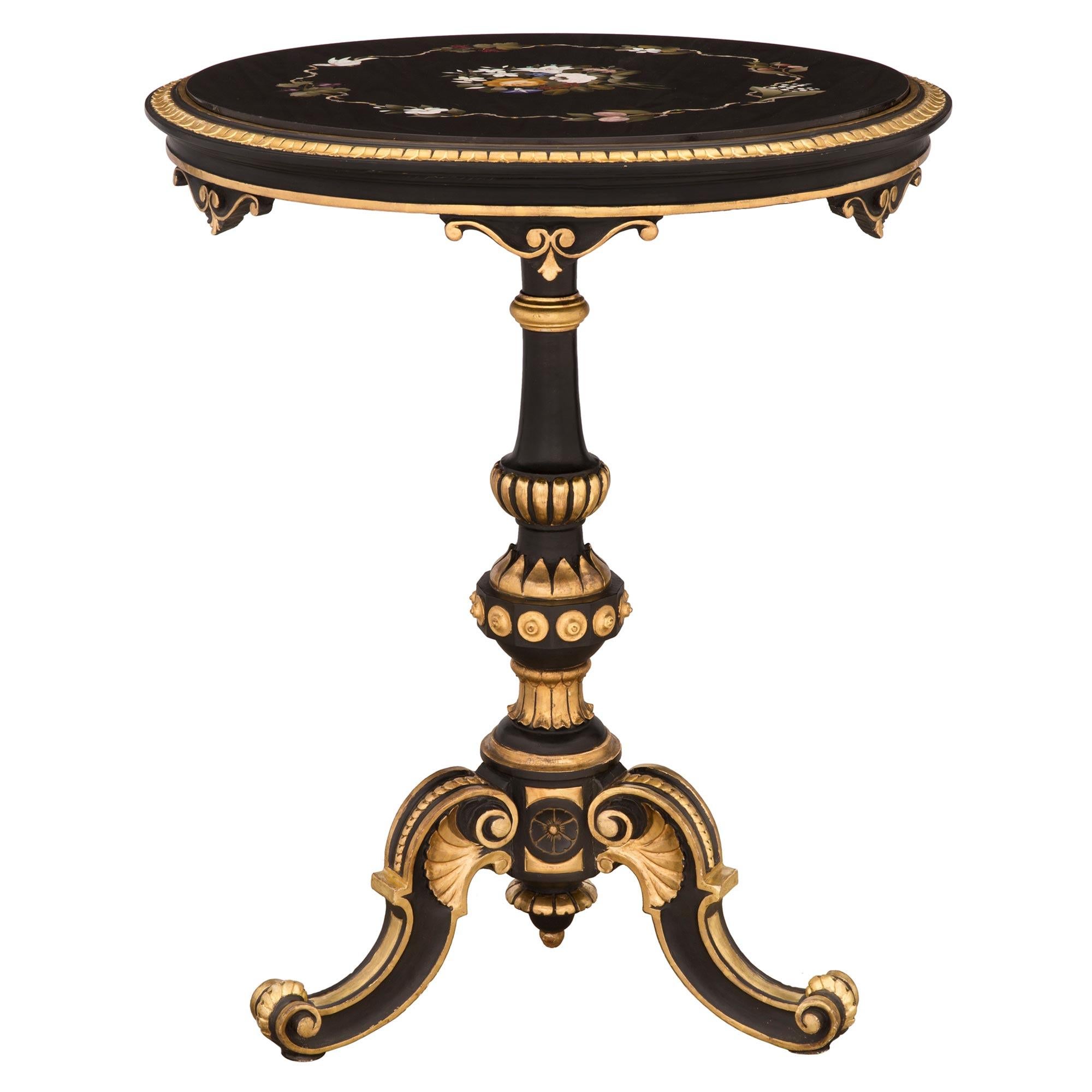 A stunning Italian early 19th century giltwood, polychrome and Pietra Dura marble Florentine side table. The table is raised by three scrolled polychrome legs with beautiful giltwood fillets and carved foliate accents. The central support displays a