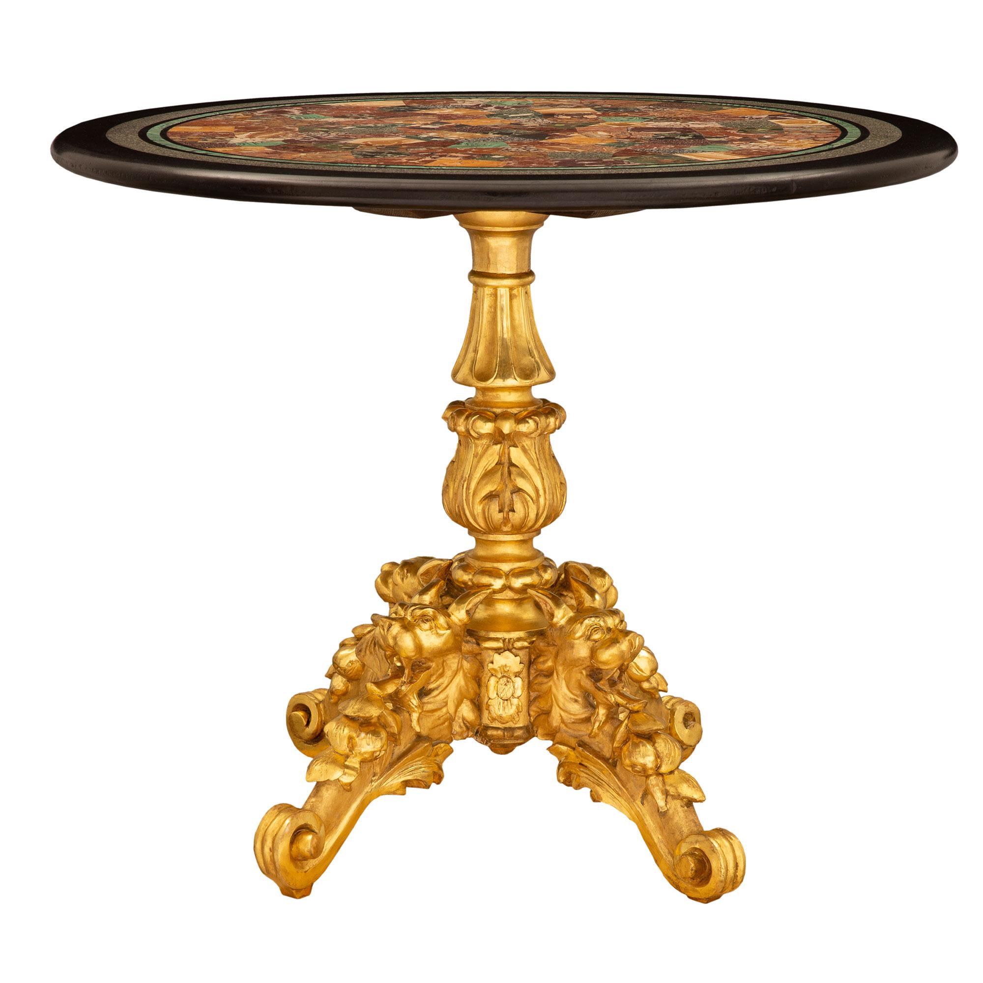 A superb and most decorative Italian 19th century giltwood and specimen marble side/center table. The circular table is raised by a striking and exquisitely carved giltwood base with elegant scrolled foliate designs and impressive finely detailed