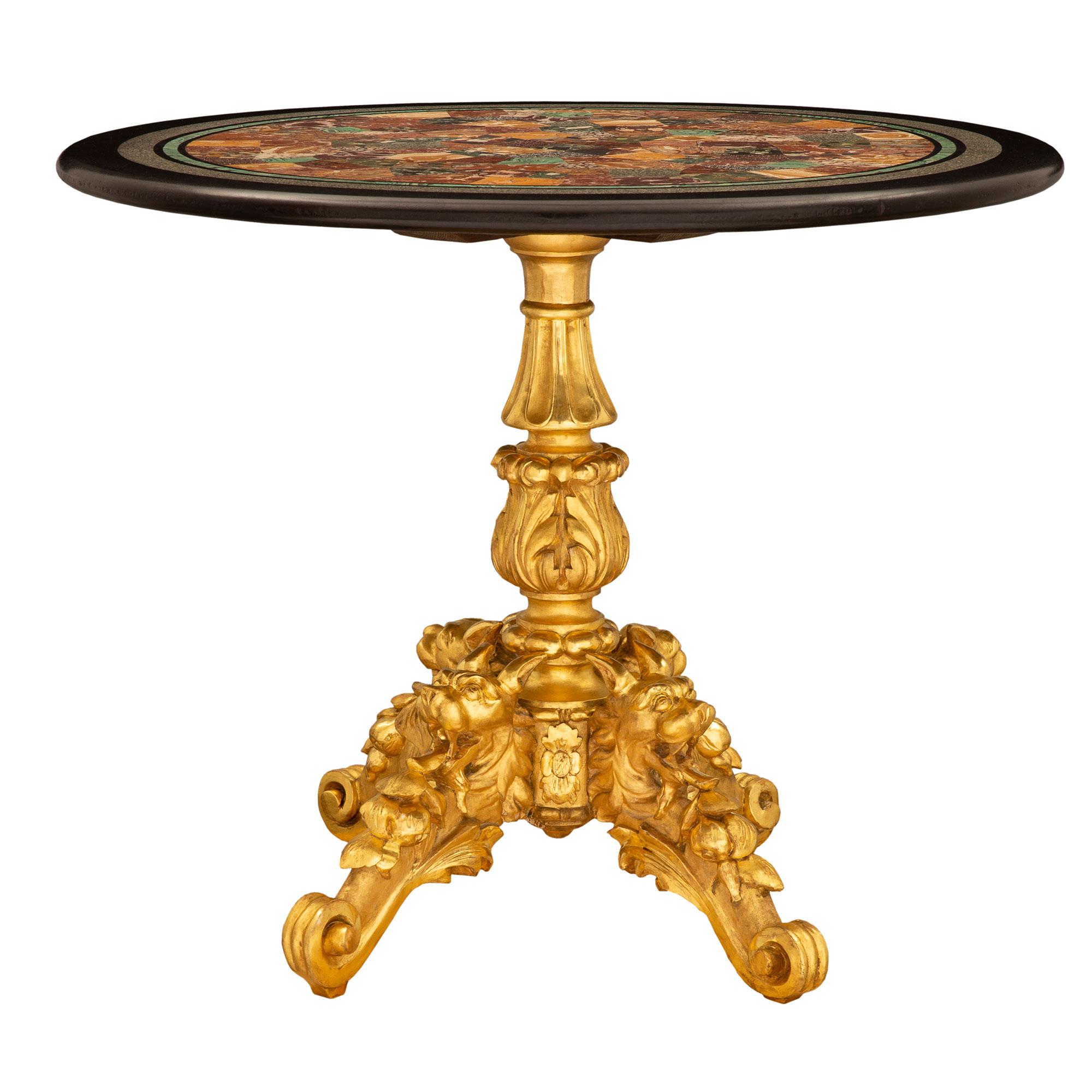 Ein hervorragender und äußerst dekorativer italienischer Beistelltisch aus Goldholz und Marmor aus dem 19. Jahrhundert. Der runde Tisch steht auf einem markanten und exquisit geschnitzten Sockel aus Goldholz mit eleganten, verschlungenen Blattwerken