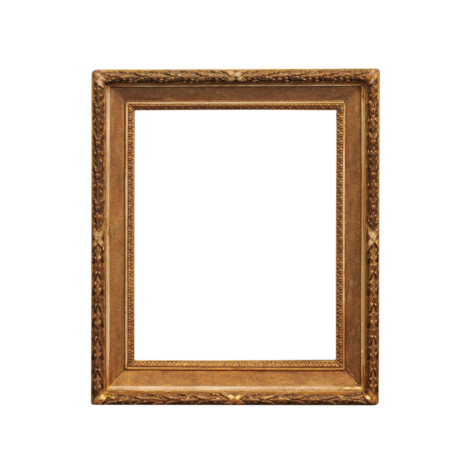 An Italian giltwood frame from the 19th century with carved foliage frieze and rais-de-cœur motifs. Hailing from the 19th century, this Italian giltwood frame is a testament to the era's affinity for ornate and elaborate details. The frame's lavish