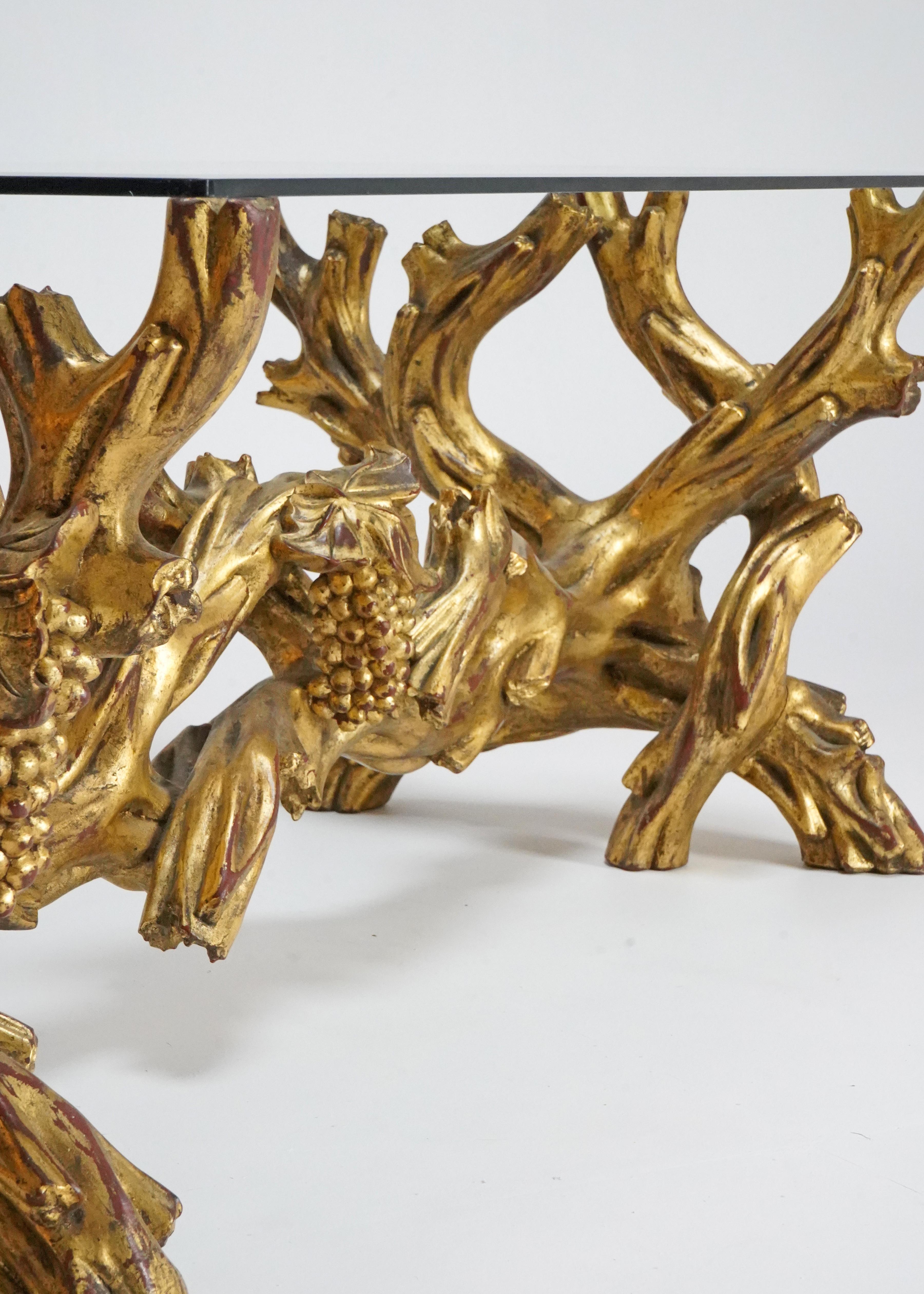 A stunning Italian hand carved 19th century gilt wood coffee table. 
It has a beautiful naturalistic base with carved vines complete with hanging bunches of grapes. The colour of the piece is warm and vivid making it a very striking object. 
 A