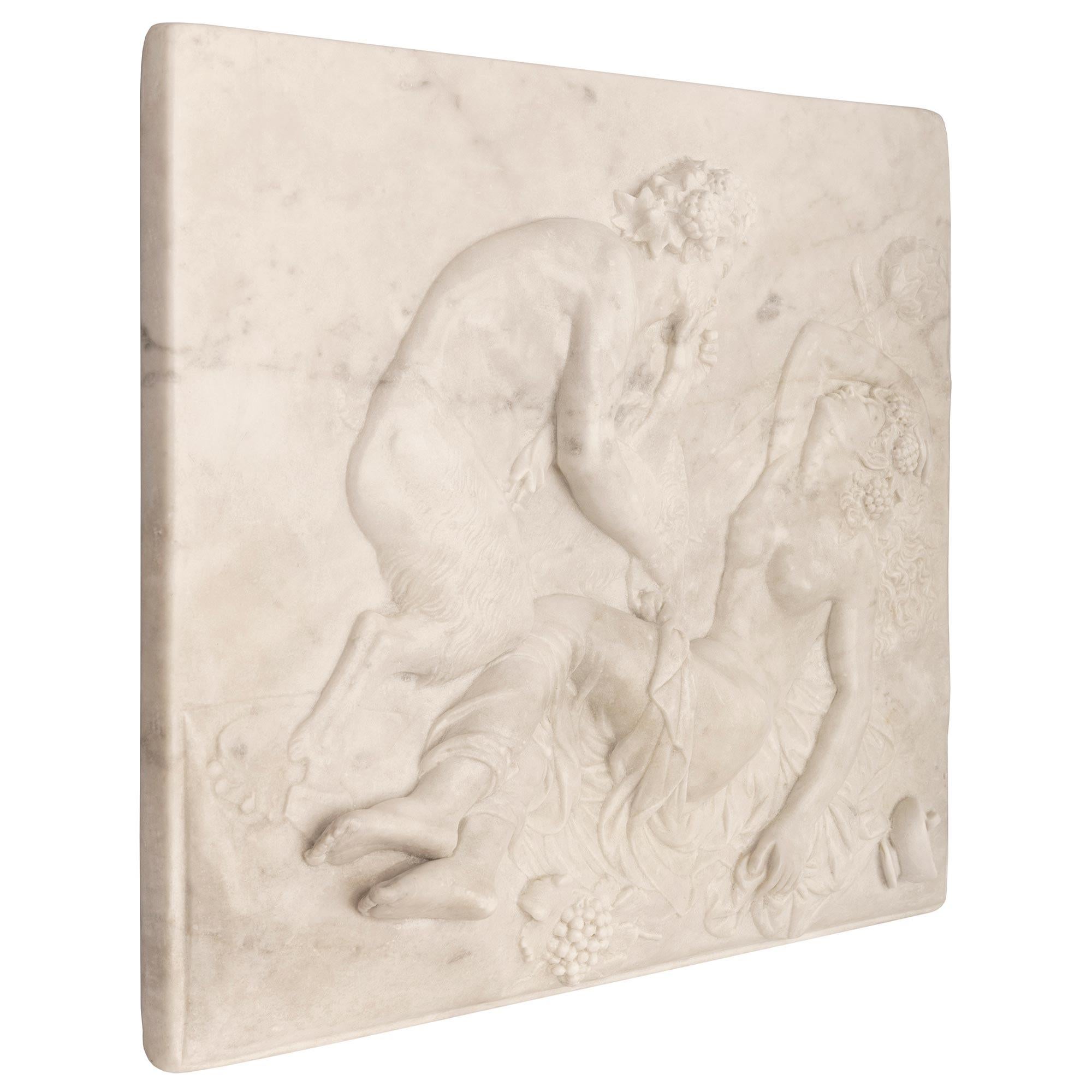 A stunning and extremely decorative Italian 19th century Neo-Classical st. Grand Tour period white carrara marble decorative wall plaque. The wonderfully executed plaque depicts a richly sculpted scene of a Bacchanalian satyr disrobing a beautiful
