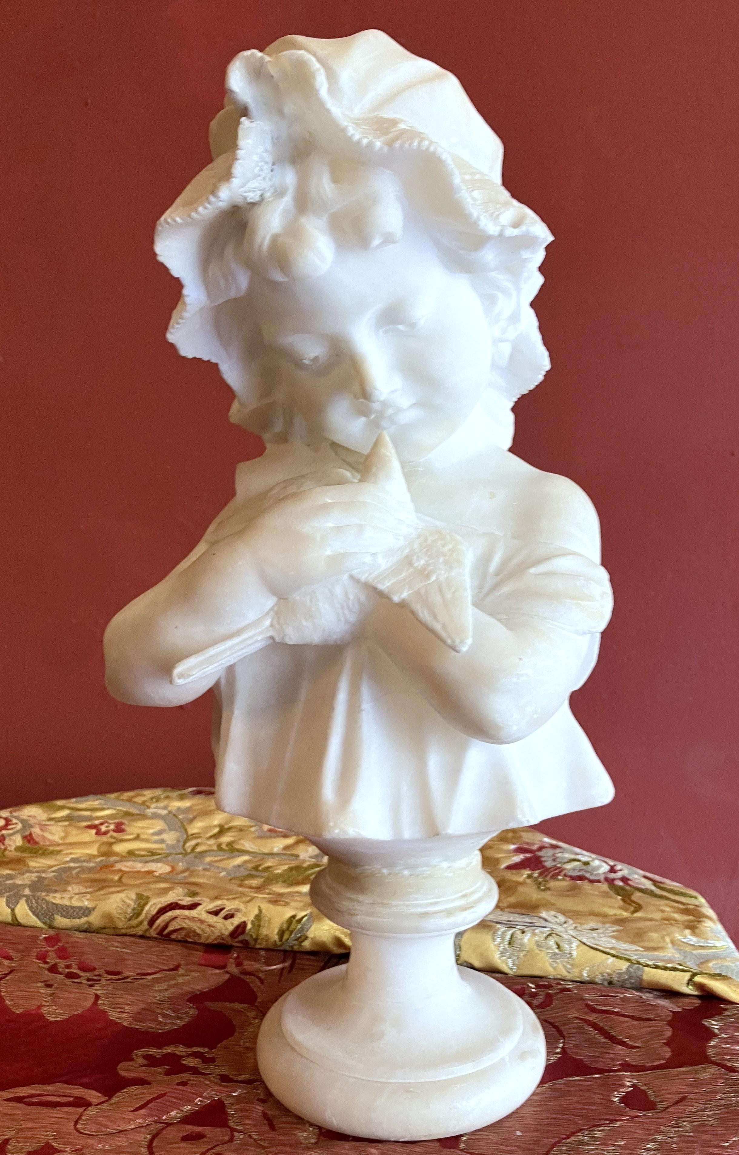 Superbe buste en albâtre italien de la fin du XIXe siècle et du début du XXe siècle, sculpté à la main, représentant une jeune fille berçant une colombe. 
La jeune fille porte un bonnet de dentelle, ses cheveux sont attachés et des mèches bouclées
