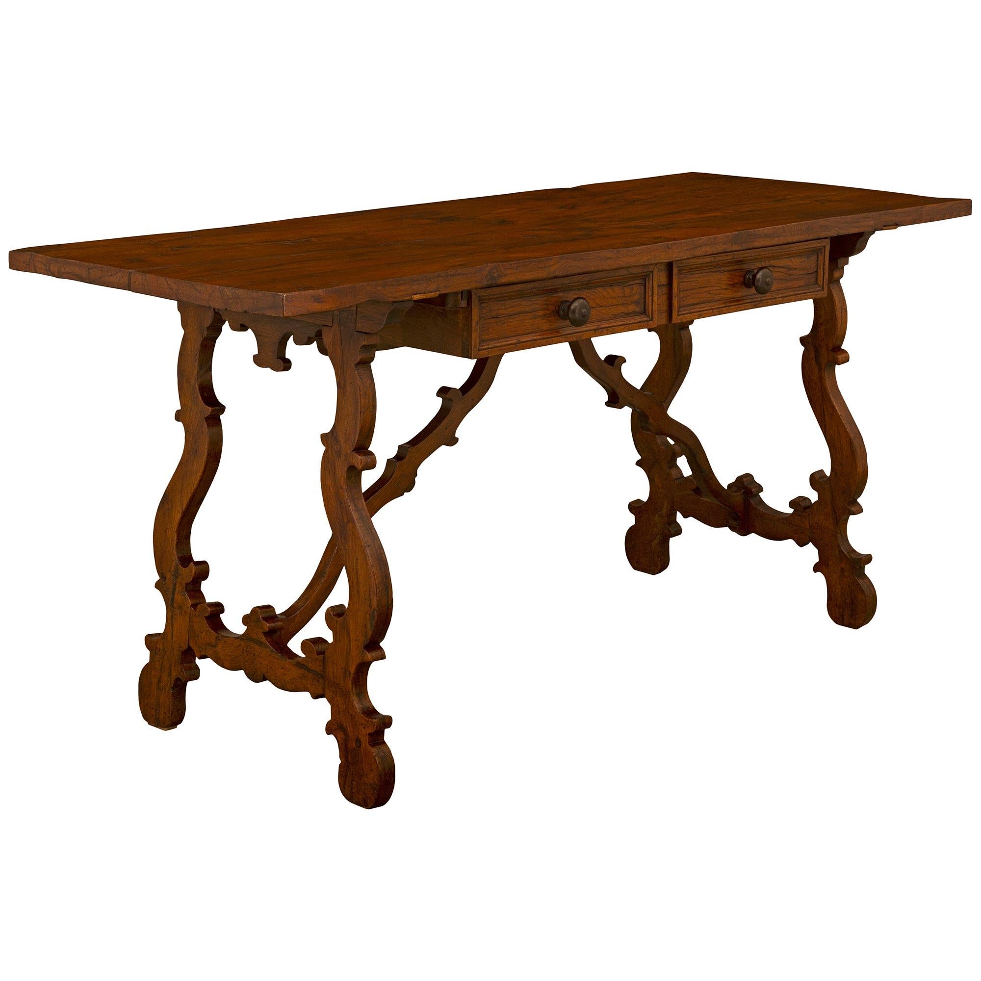 





An attractive Italian 19th century Oak trestle table/desk. The honey colored Oak table is raised by slanted pierced supports with scrolled designs and a bottom central 'Fleur de Lys' shape. The two legs are joined by two scalloped stretchers.