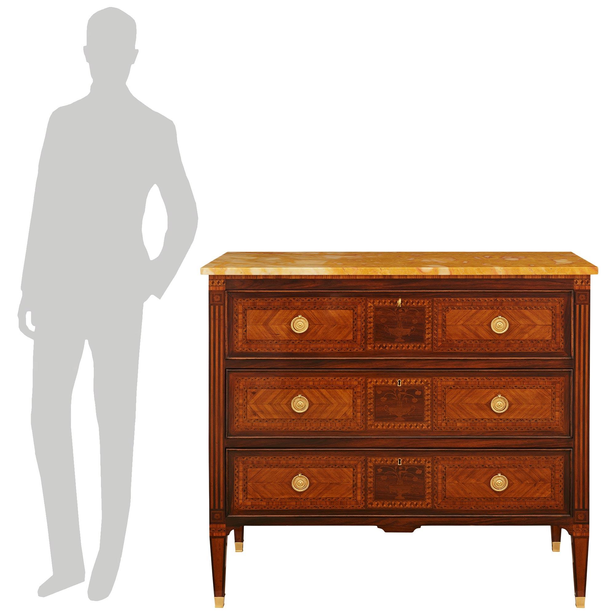 Un'elegante e decoratissima commode italiana del XIX secolo in legno Kingwood, Tulipano, Ormolu e marmo di Siena. Questa splendida cassettiera a tre cassetti poggia su quattro gambe quadrate affusolate e rifinite con sabot avvolgenti in Ormolu. Ogni