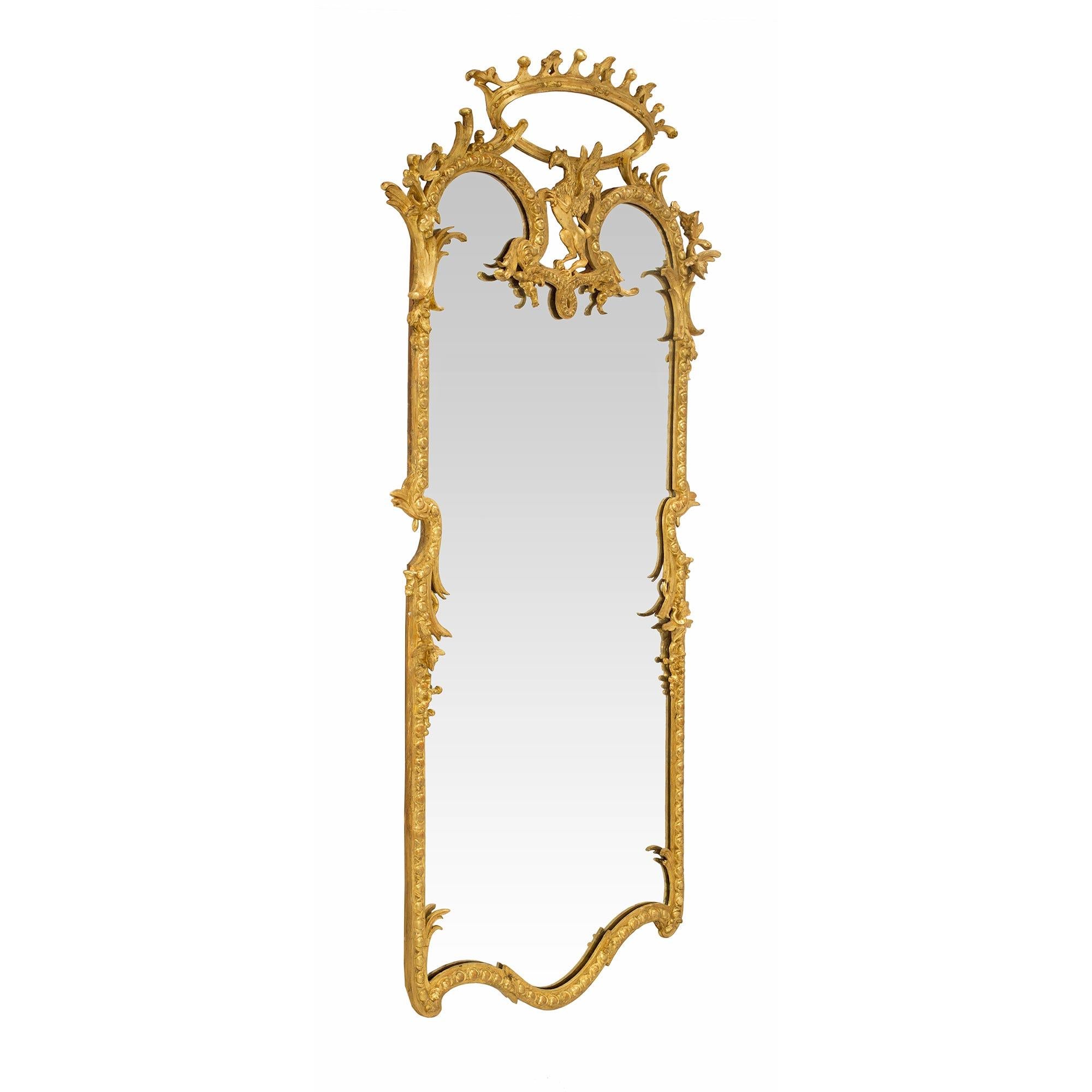 A sensational and uniquely shaped Italian Louis XIV st. 19th century giltwood mirror. The elongated giltwood frame has an arbalest shaped bottom with an egg and dart design. At each side are richly chased acanthus leaves and concave designs with