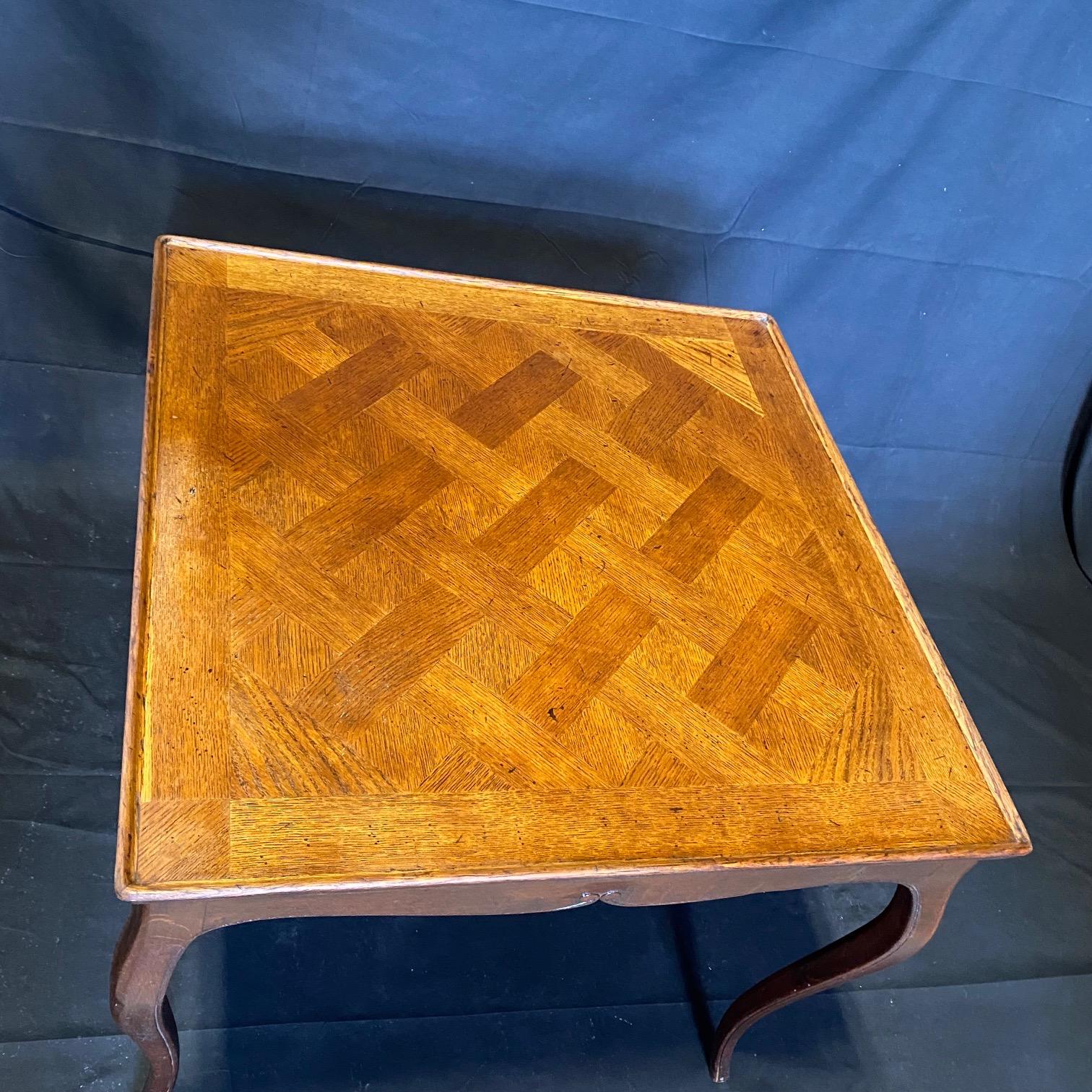 Really lovely classic Italian large side table or smaller desk with gracefully curved cabriole legs. Sturdy yet delicate oak table with beautiful rimmed carvings throughout legs and apron. The top displays a herringbone parquet pattern and the edges
