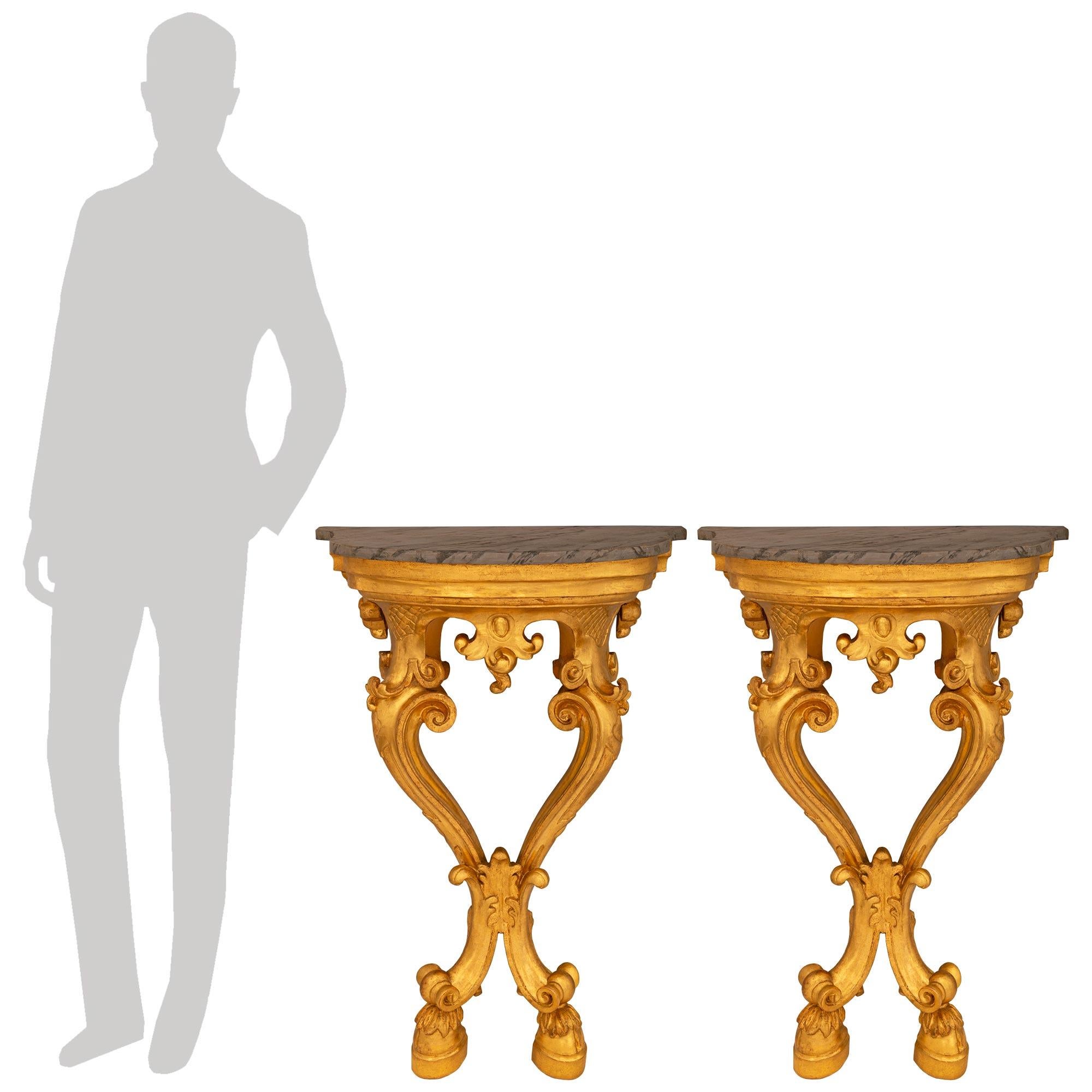 Ein beeindruckendes und äußerst dekoratives Paar italienischer Konsolen aus Giltwood und künstlich bemaltem Marmor im Stil Louis XV des 19. Jede beeindruckende Wandkonsole steht auf zwei S-förmig geschwungenen Beinen und wird von blattgeschmückten