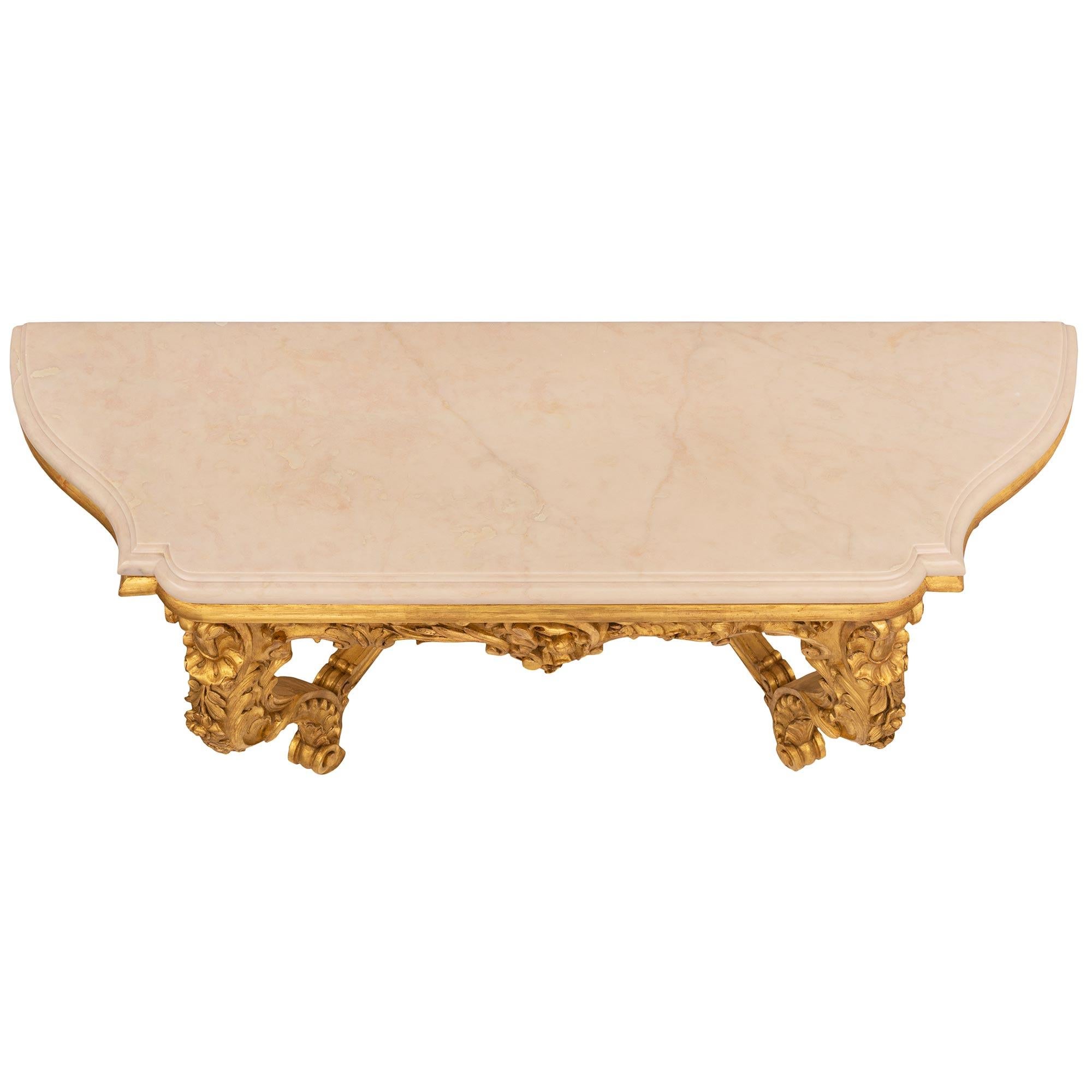 A stunning Italian 19th century Louis XV st. giltwood and Jaune de Valence marble console. The wall mounted console is raised by outstanding scrolled tapered legs with charming feet adorned with large acanthus leaves, gadroon movements, and charming