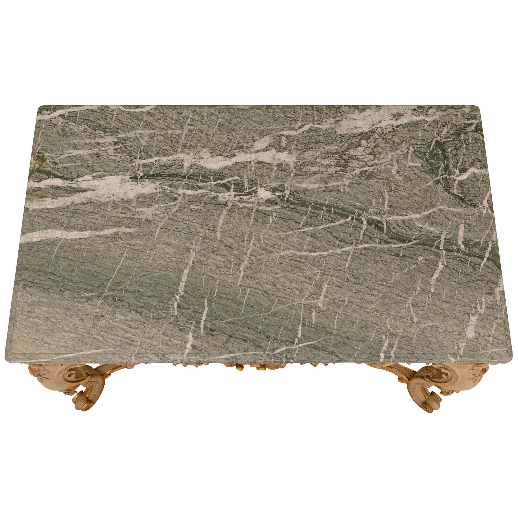 Impresionante y extremadamente decorativa mesa de centro italiana del siglo XIX de estilo Luis XV de madera patinada, madera dorada y mármol Vert Campan. La mesa se eleva sobre hermosas patas con roleos y hojas de acanto finamente talladas bajo las