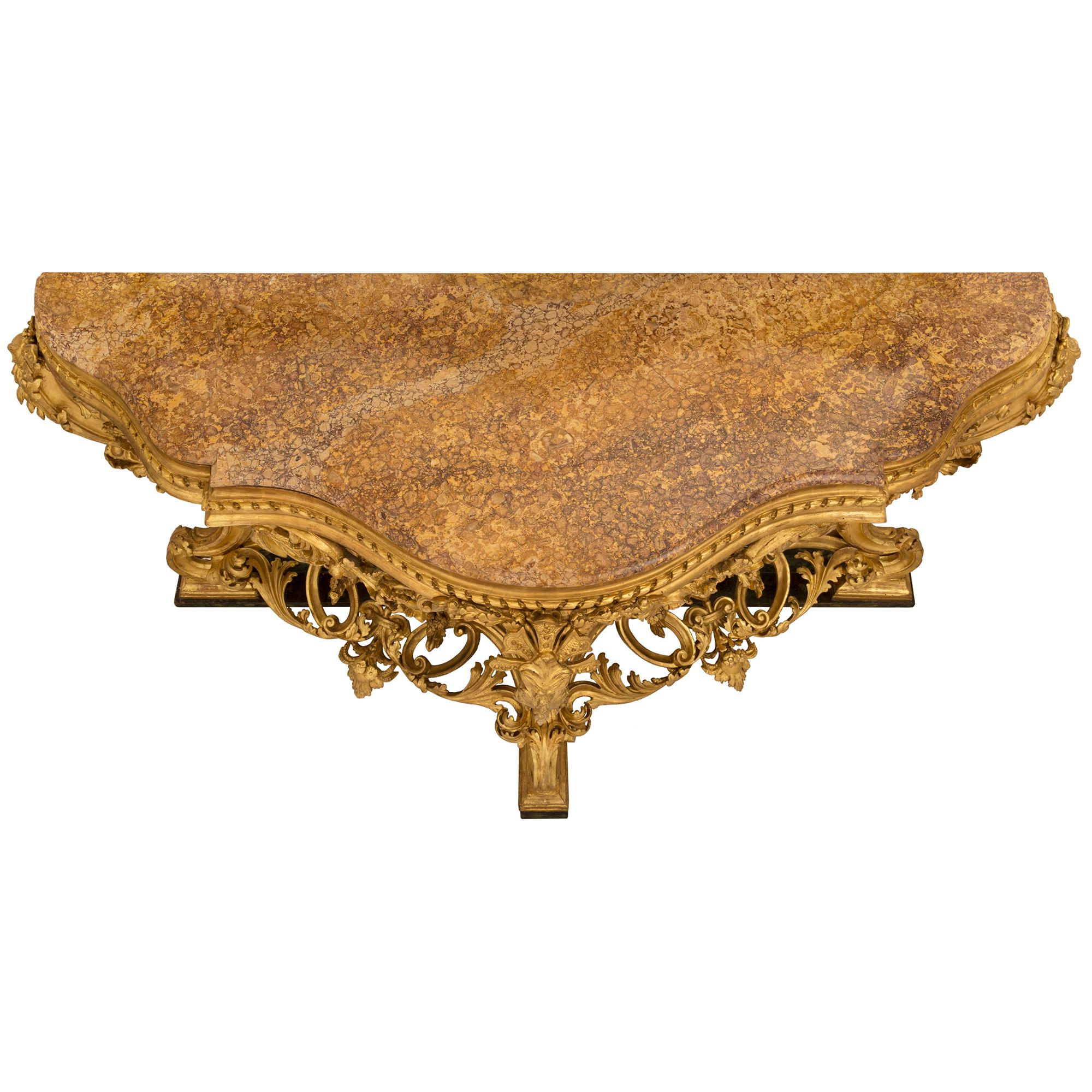 A stunning Italian 19th century Louis XV st. faux painted marble, giltwood and Brocatelle d'Espagne marble console. The freestanding console is raised by a wonderfully executed faux painted marble base and three impressive richly carved scrolled