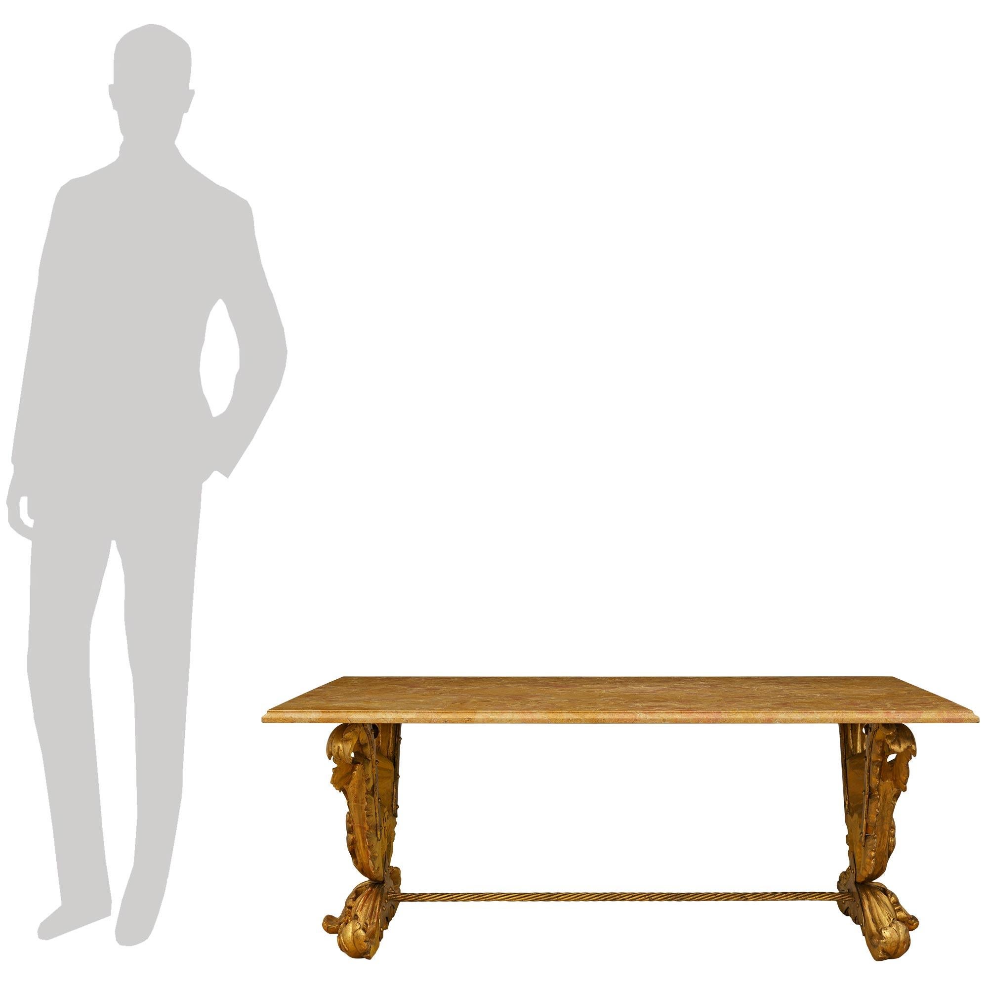 Una exquisita y singular mesa de centro italiana del siglo XIX de estilo Luis XV de madera dorada y mármol de Varois. Esta impresionante mesa de centro rectangular se eleva sobre dos soportes de hojas de acanto en madera dorada ricamente tallada,
