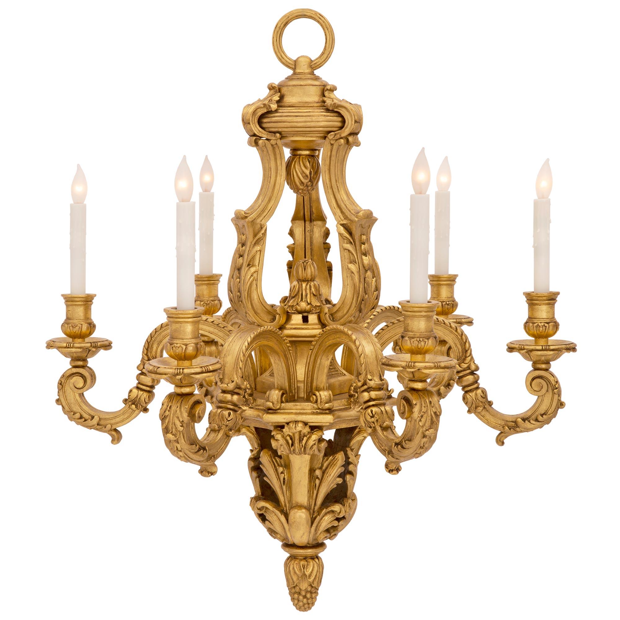 Un beau lustre italien du 19ème siècle de grande qualité en bois doré de style Louis XV. Le lustre à six bras est centré par un impressionnant épi de faîtage inférieur finement détaillé avec de grandes feuilles d'acanthe percées et richement