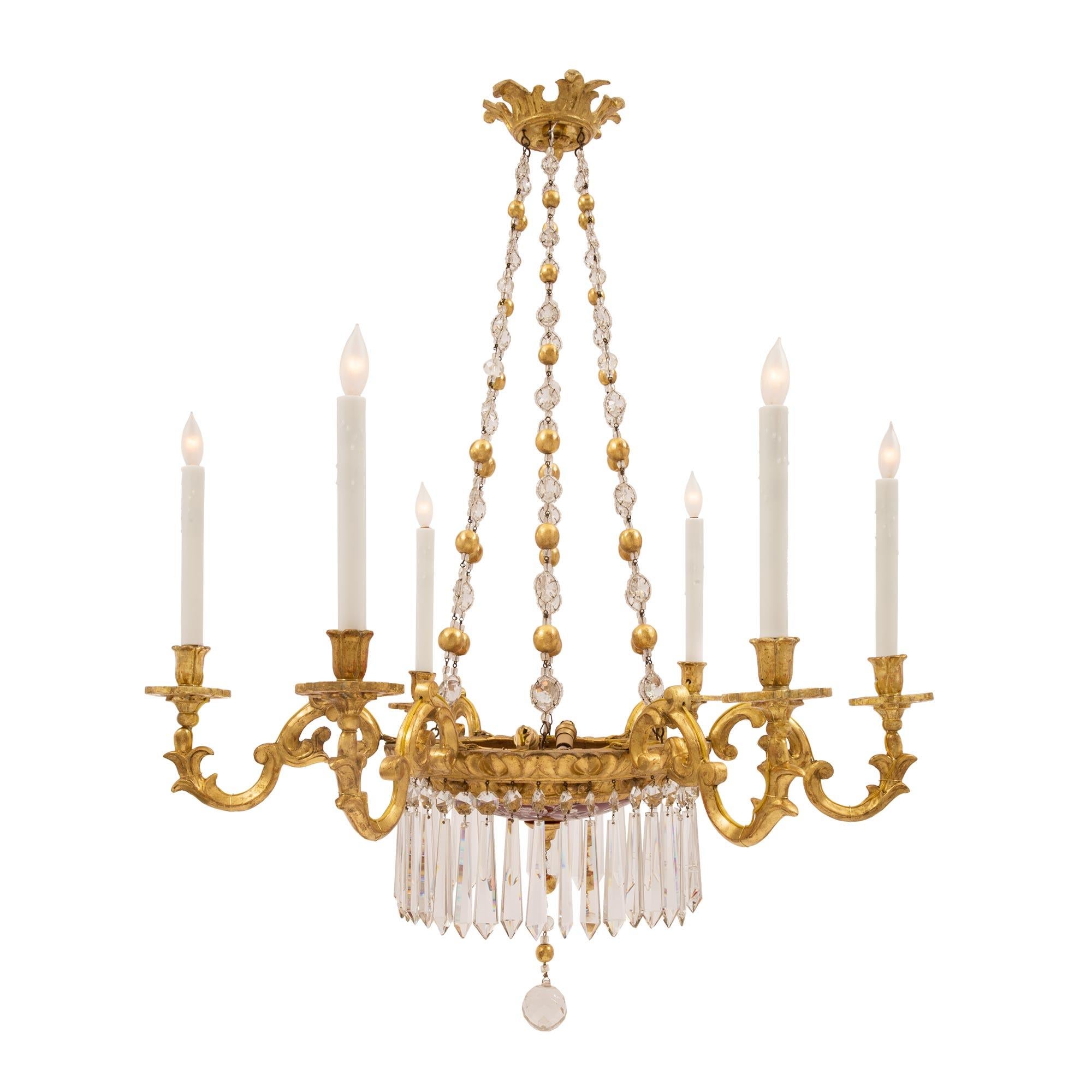 A stunning Italian 19th century Louis XV st. giltwood, crystal and ox blood red etched glass six arm chandelier. The chandelier is centered by an elegant cut crystal ball below a striking and most decorative ox blood red glass dome with etched