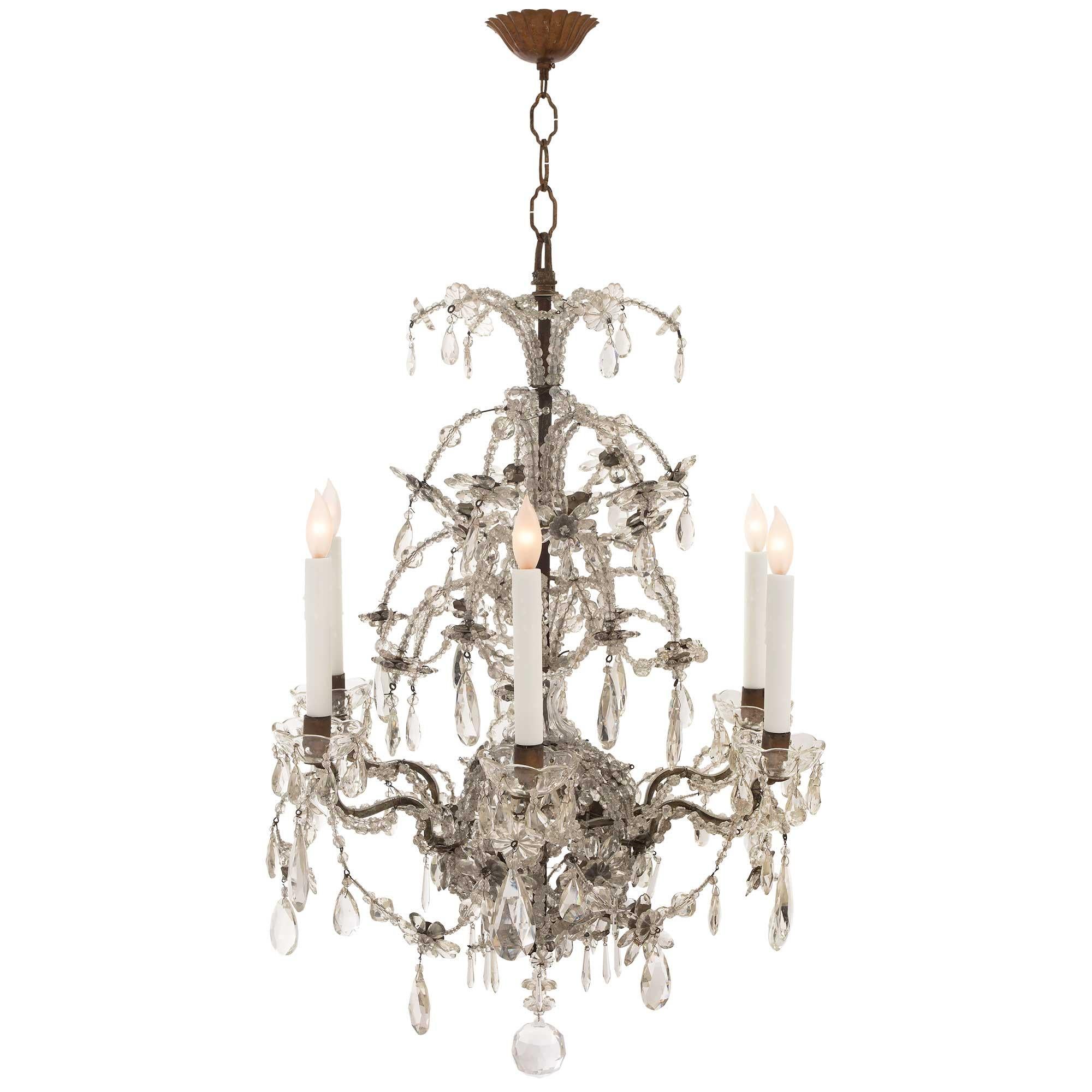 A beautiful Italian 19th century Louis XV st. cut glass, crystal and iron six arm chandelier. The chandelier is centered by a fine cut crystal ball at the bottom. Above is a fine array of prism and tear drop shaped crystal pendants and striking