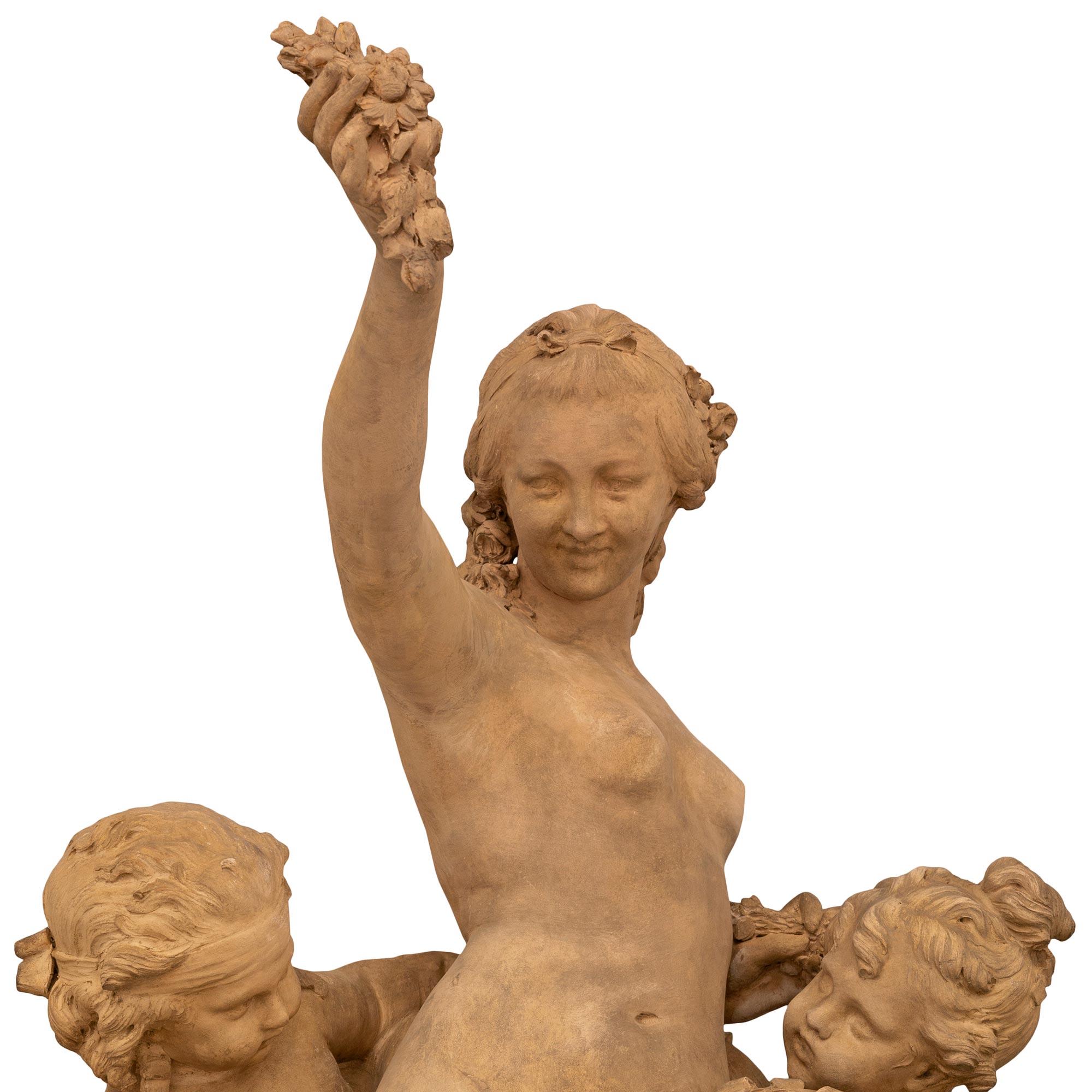 Exceptionnelle statue italienne du XIXe siècle de style Louis XVI en terre cuite, bronze doré et marbre Sarrancolin, attribuée à Clodion. La statue repose sur son élégant socle circulaire d'origine en marbre de Sarrancolin, orné de délicats motifs