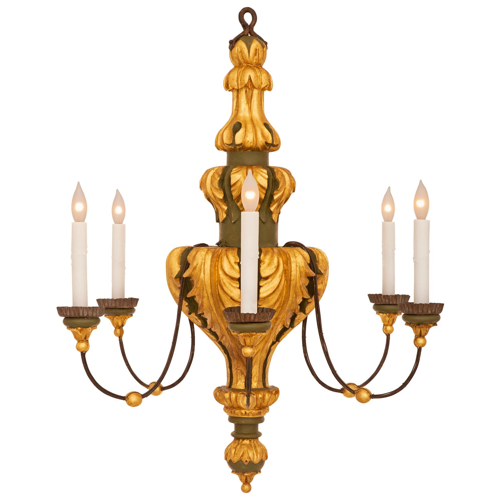 A beautiful and most most decorative Italian 19th century Louis XVI st. patinated and giltwood chandelier. The six arm chandelier is centered by a lovely topie shaped and foliate ball bottom finial below the exceptional and unique baluster shaped