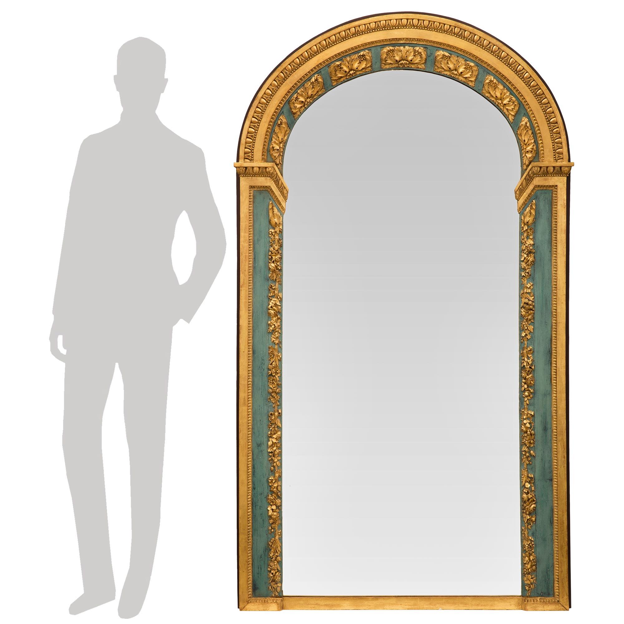 An exceptional and incredibly unique Italian 19th century Louis XVI st. patinated and giltwood mirror. The mirror retains its original mirror plate set within a most decorative straight and arched shaped frame. The frame displays a superb array of