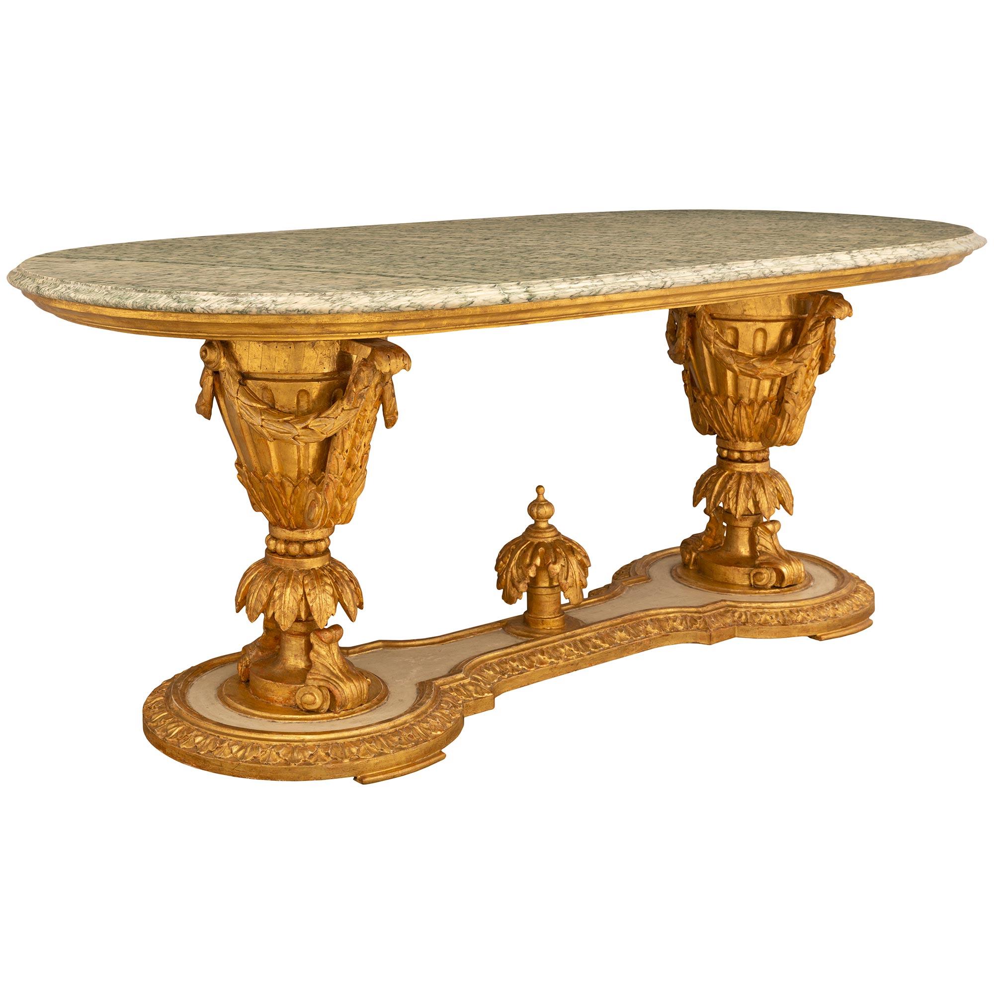 A stunning and very unique Italian 19th century Louis XVI st. patinated, giltwood and Vert Campan center table. The oblong center table is raised by the most decorative base with fine mottled feet below the patinated off white bottom tier with a