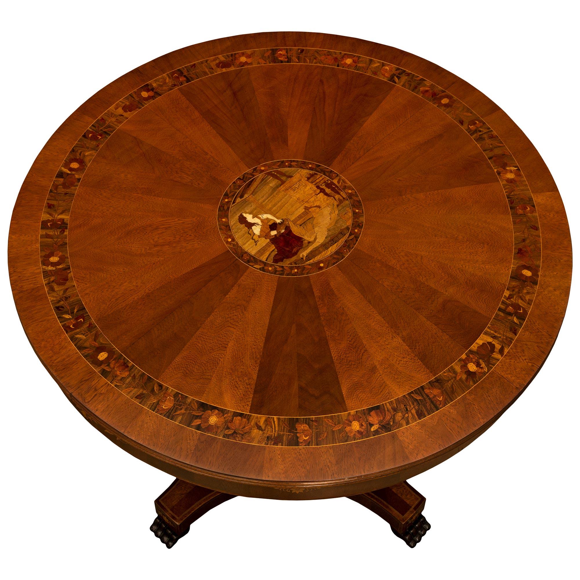 Très belle table centrale italienne du XIXe siècle de style Louis XVI en noyer, acajou et bois exotiques. La table est surmontée d'un piédestal carré dont les côtés concaves présentent des palmettes incrustées au-dessus des supports à pattes.