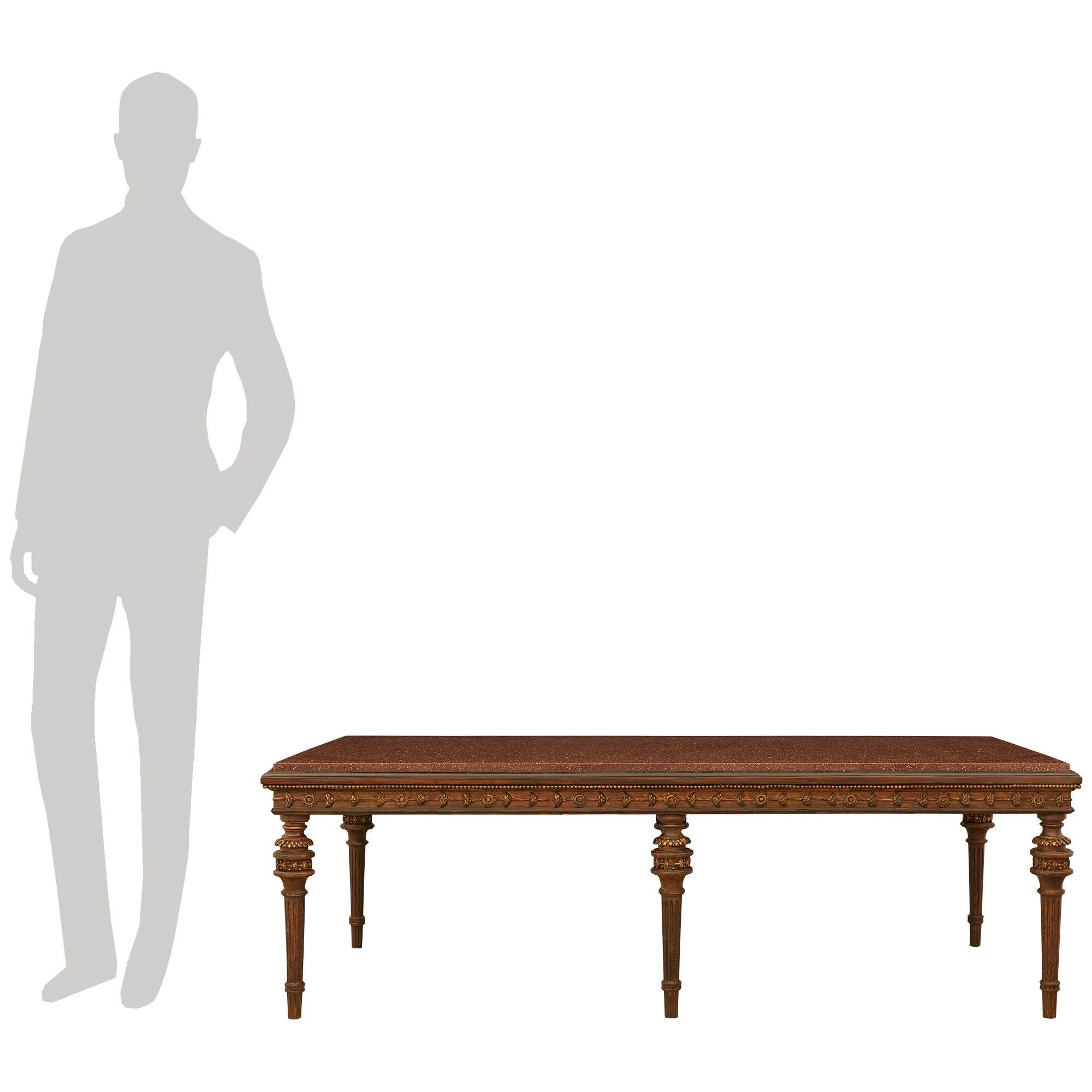 Ein hübscher und sehr dekorativer italienischer Couchtisch aus patiniertem Holz, Giltwood und rotem Porphyr aus dem 19. Dieser wunderbare Couchtisch steht auf konischen, kannelierten und patinierten Holzbeinen, die an der Oberseite mit Bändern aus