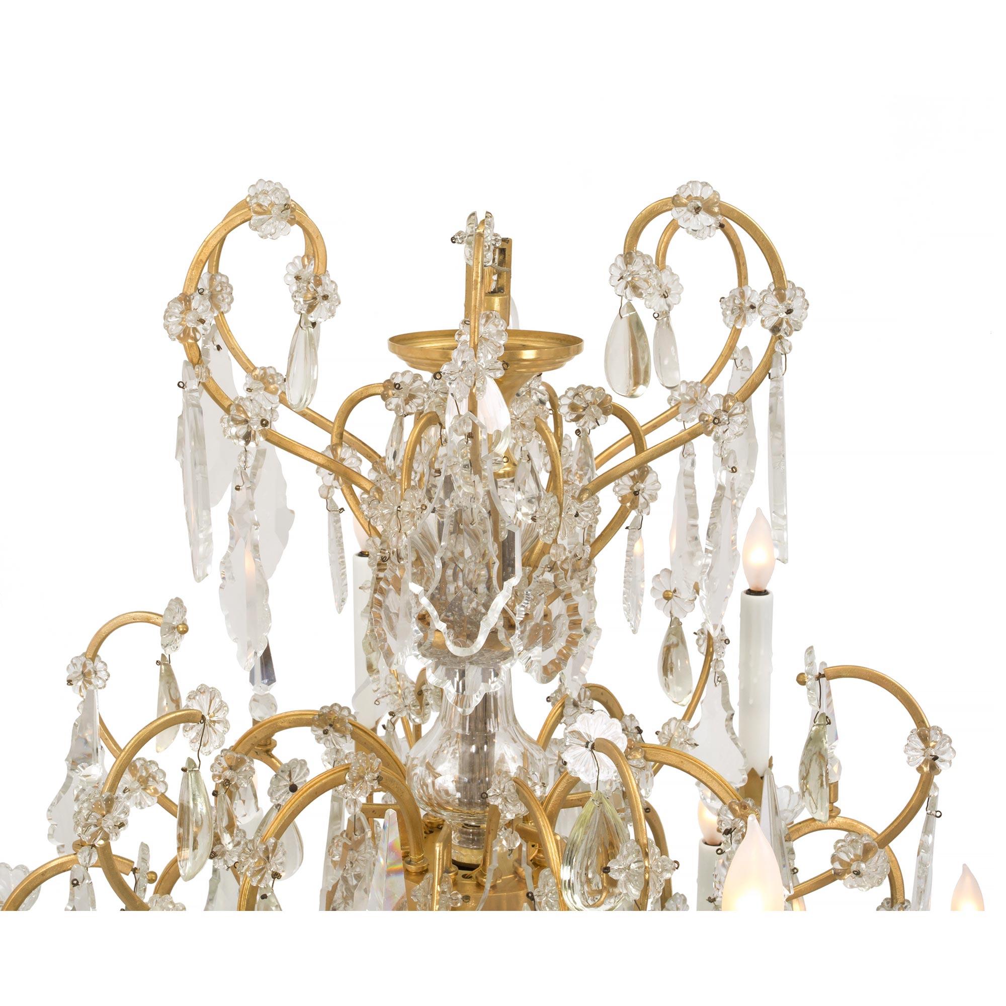 A stunning Italian 19th century Louis XVI st. ormolu and Baccarat crystal eighteen arm chandelier. The chandelier is centered by a fine crystal ball and six scrolled arms with beautiful alternating cut crystal pendants and crystal daggers. The